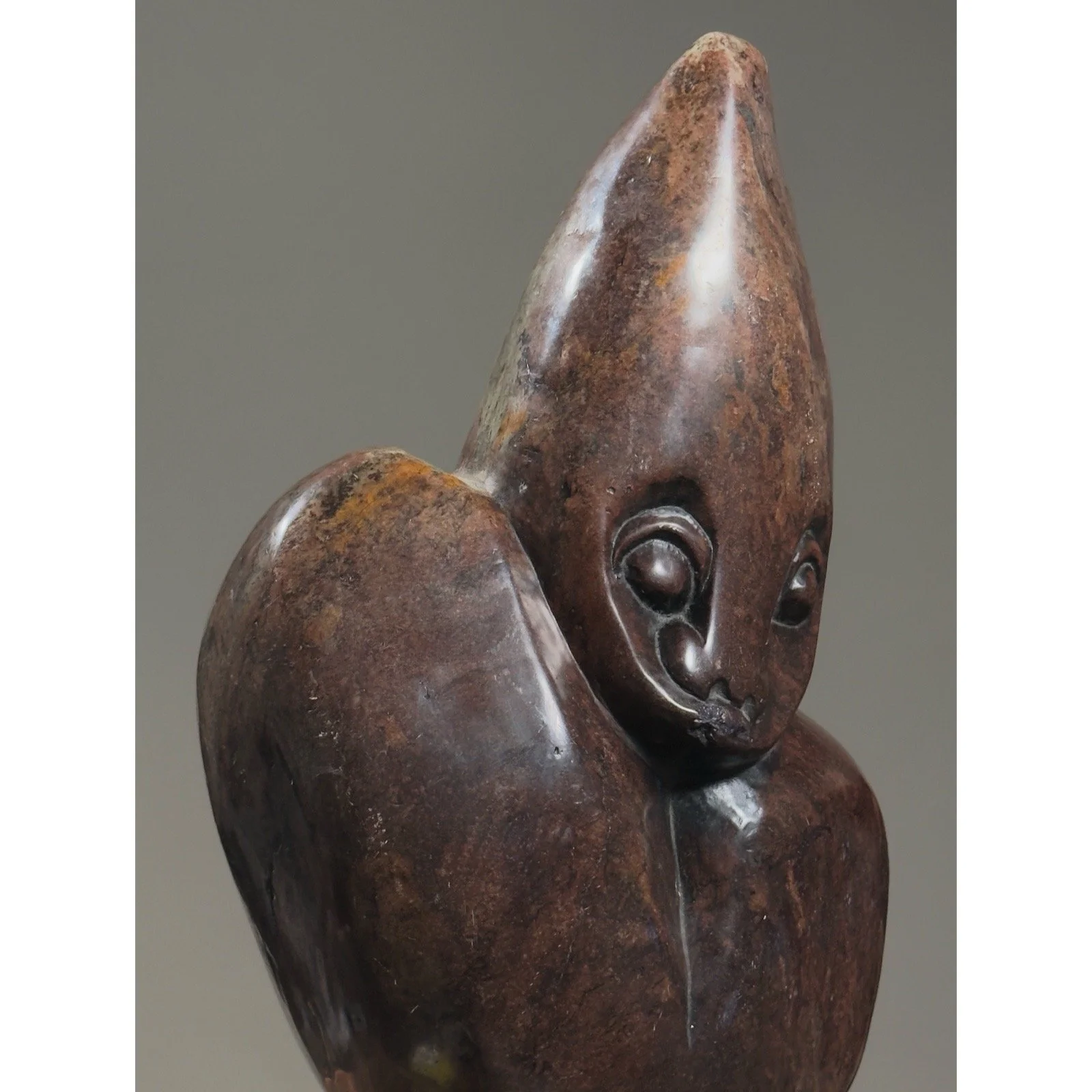 Three-quarter view of hand-carved abstract Zimbabwean sculpture showing smooth and textured stone surfaces.