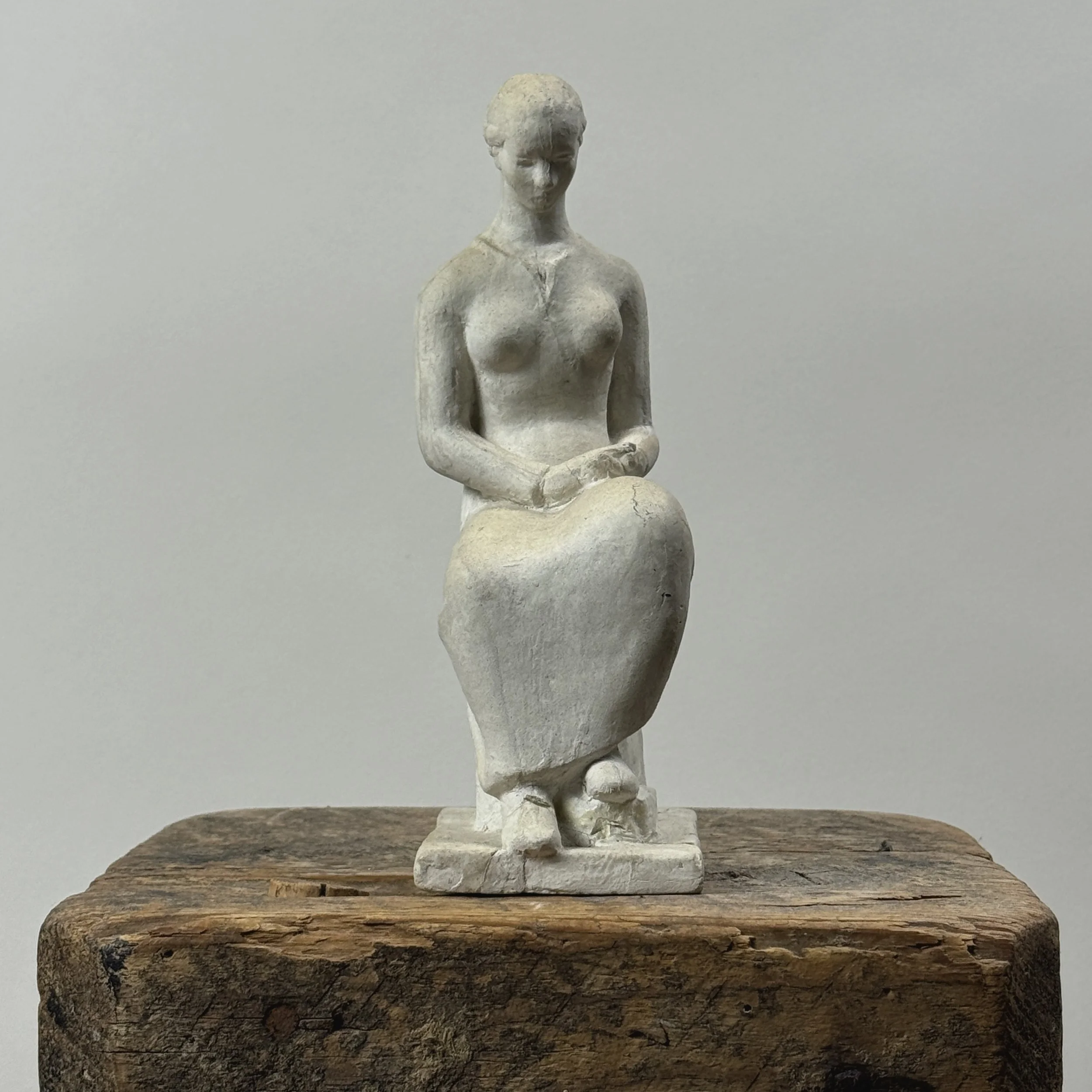 Vintage painted plaster statue of seated woman. Signed Rudy on back. 8.25 inches high.