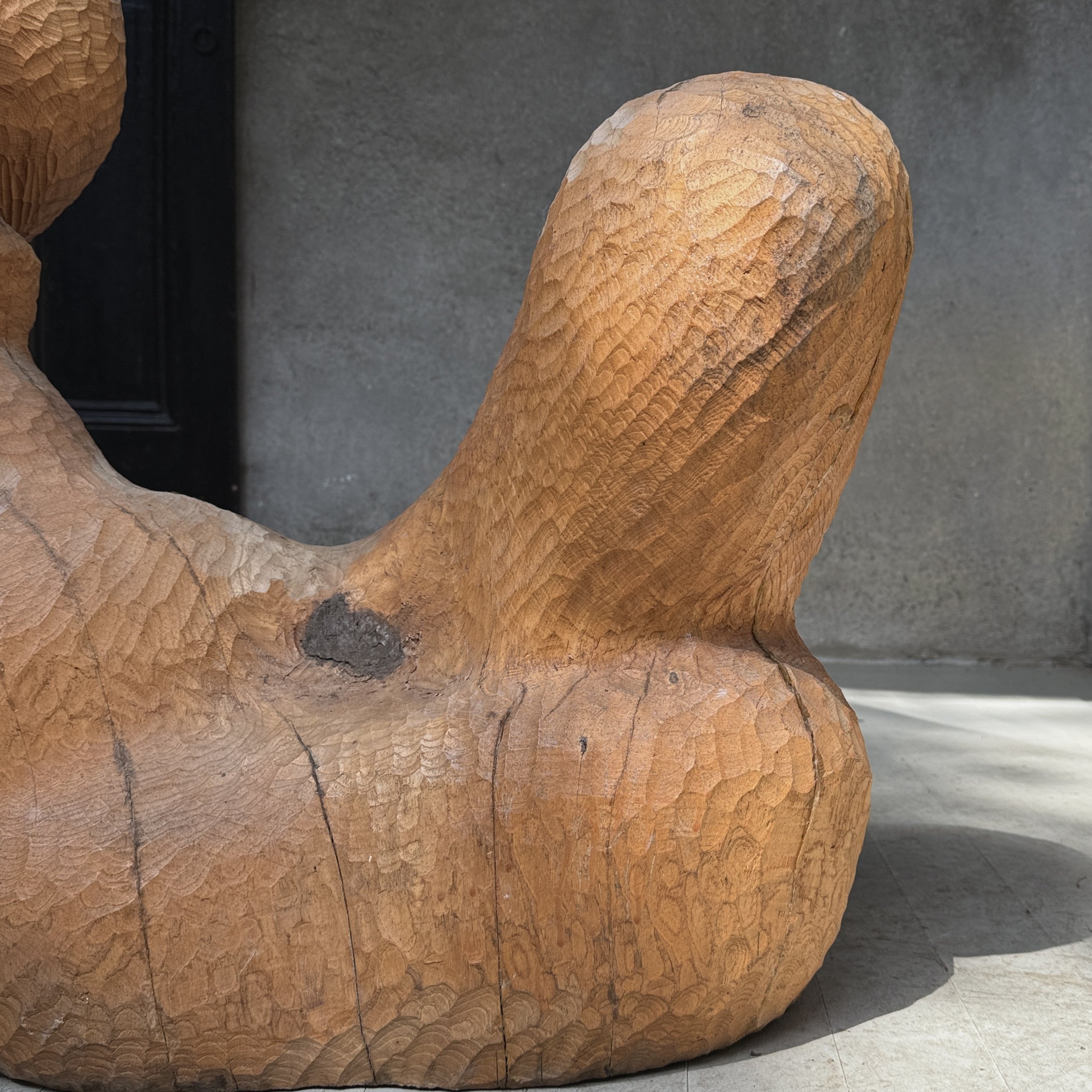 Detail of the figure's legs and feet carved in simplified modernist style