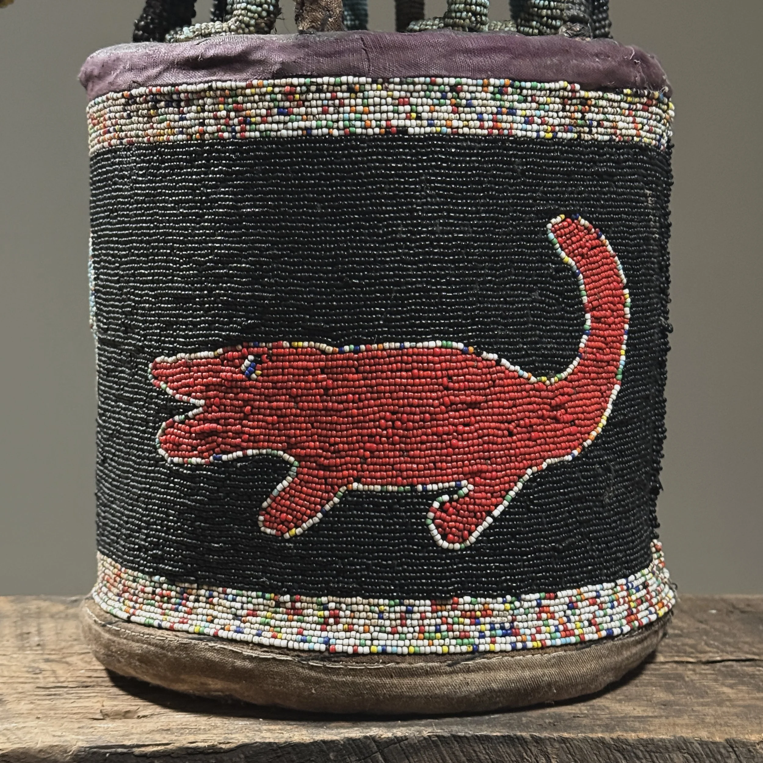 Close-up of beaded crocodile motif adorning the cylindrical base of a Yoruba royal crown