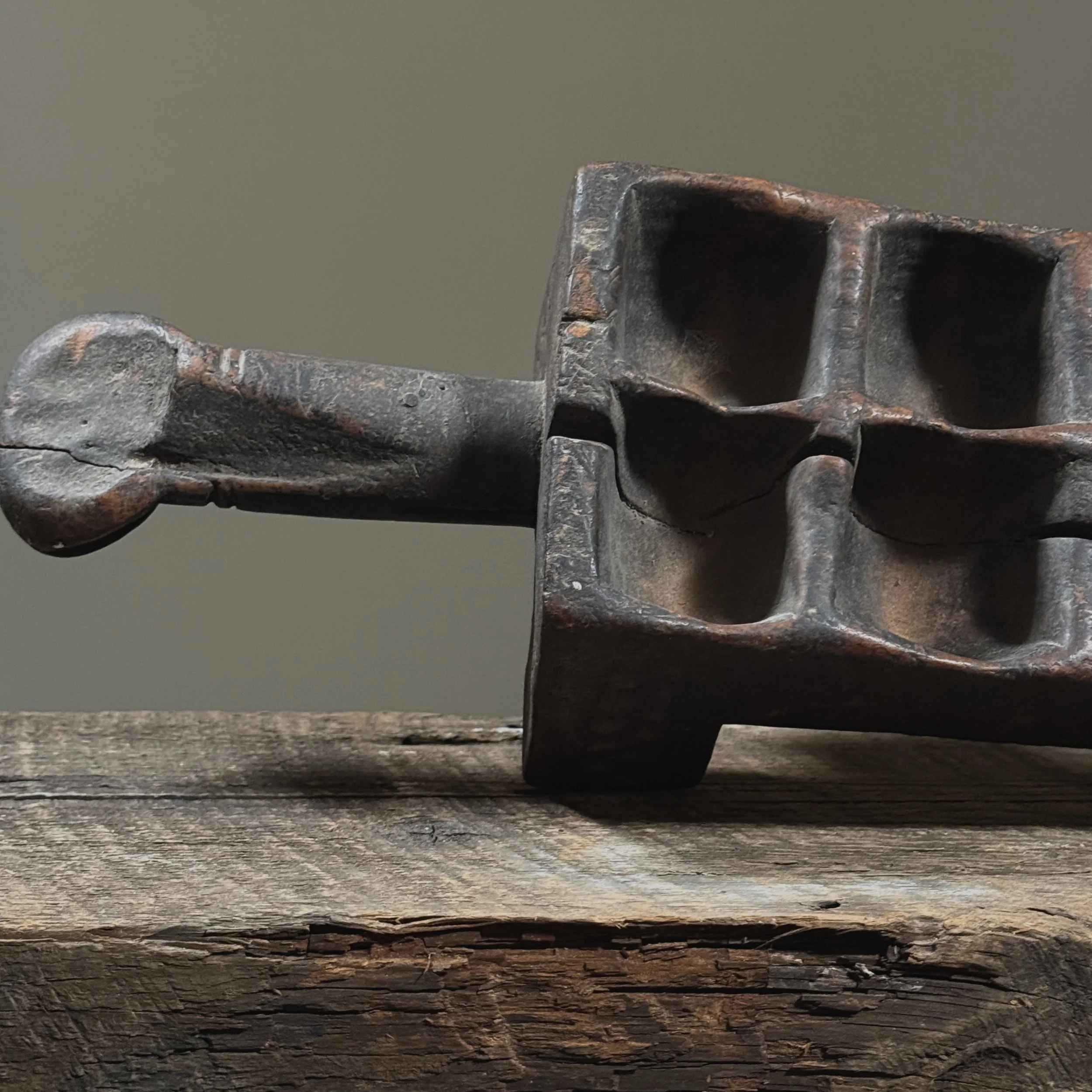 Antique mancala board with geometric etching and visible wear from use