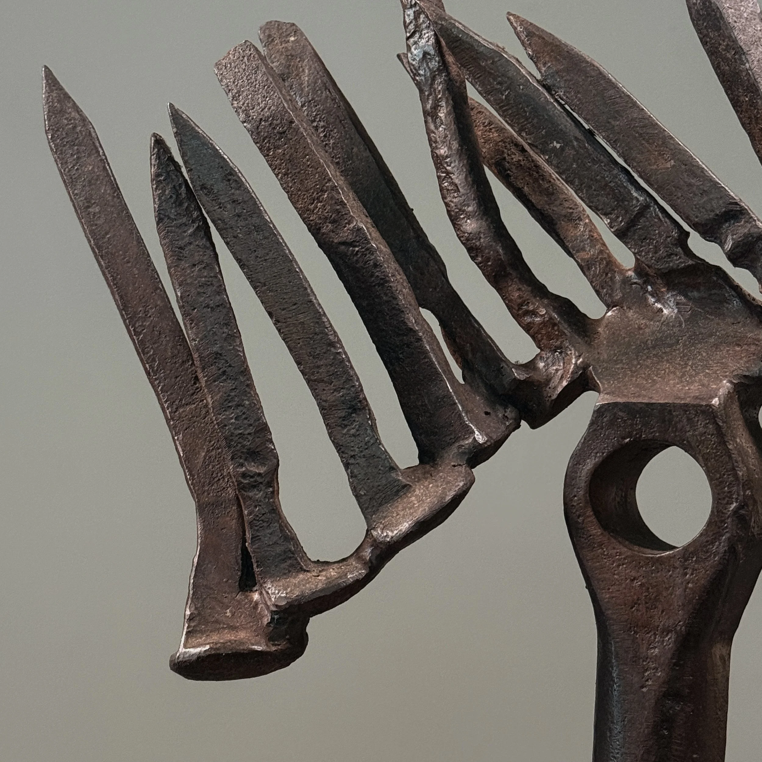 Close-up of forged iron elements. Raw material texture and industrial finish visible.