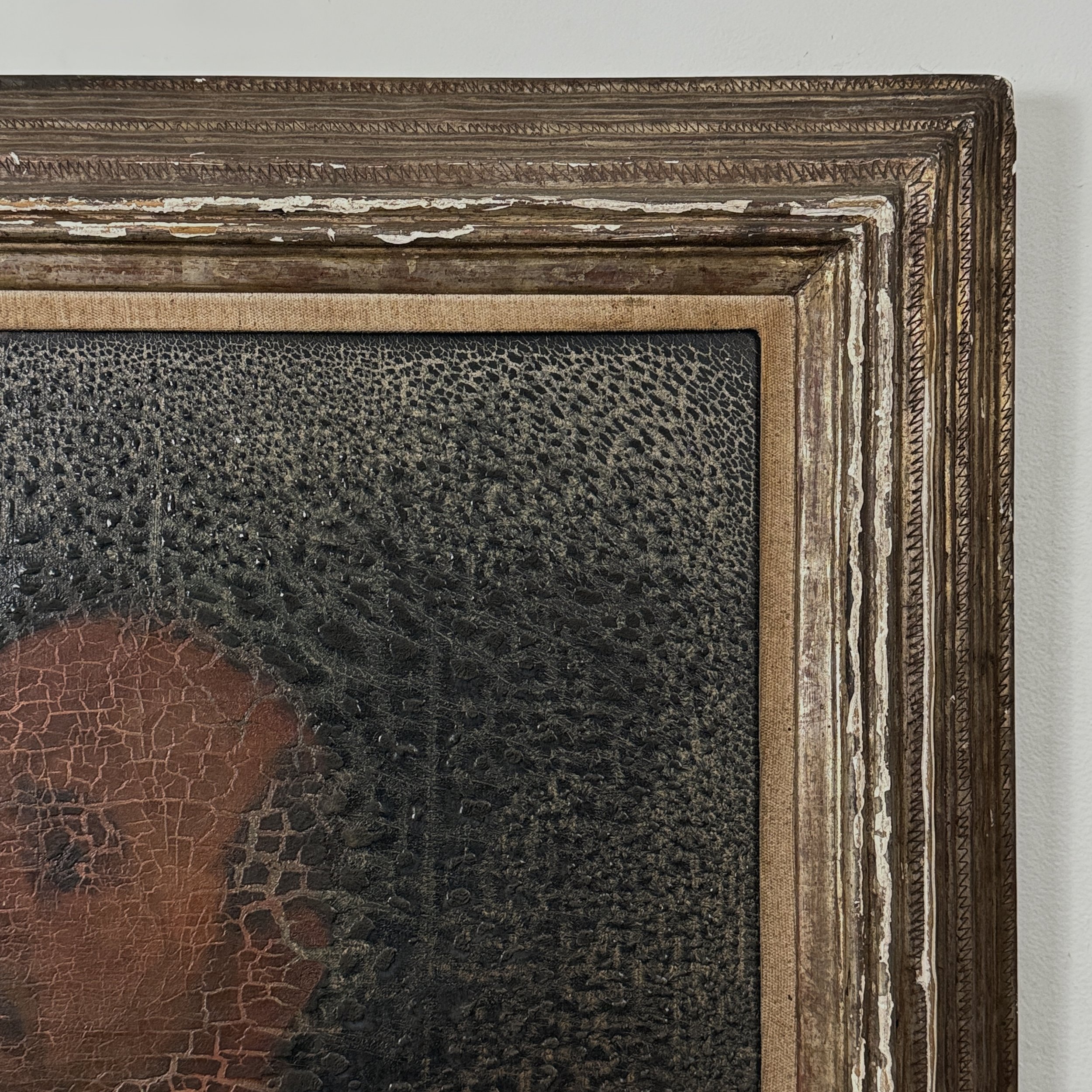 Detail of the frame's corner, showing carving style and losses.