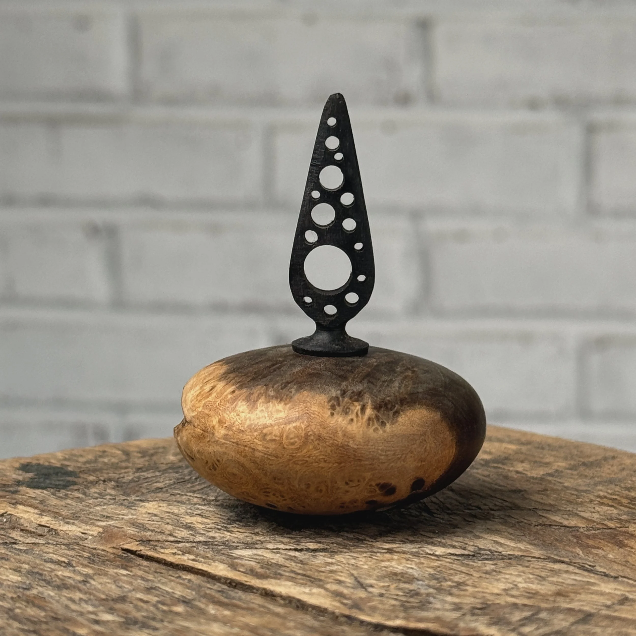 Vintage miniature turned burl wood vessel with hand-carved ebony topper on white background