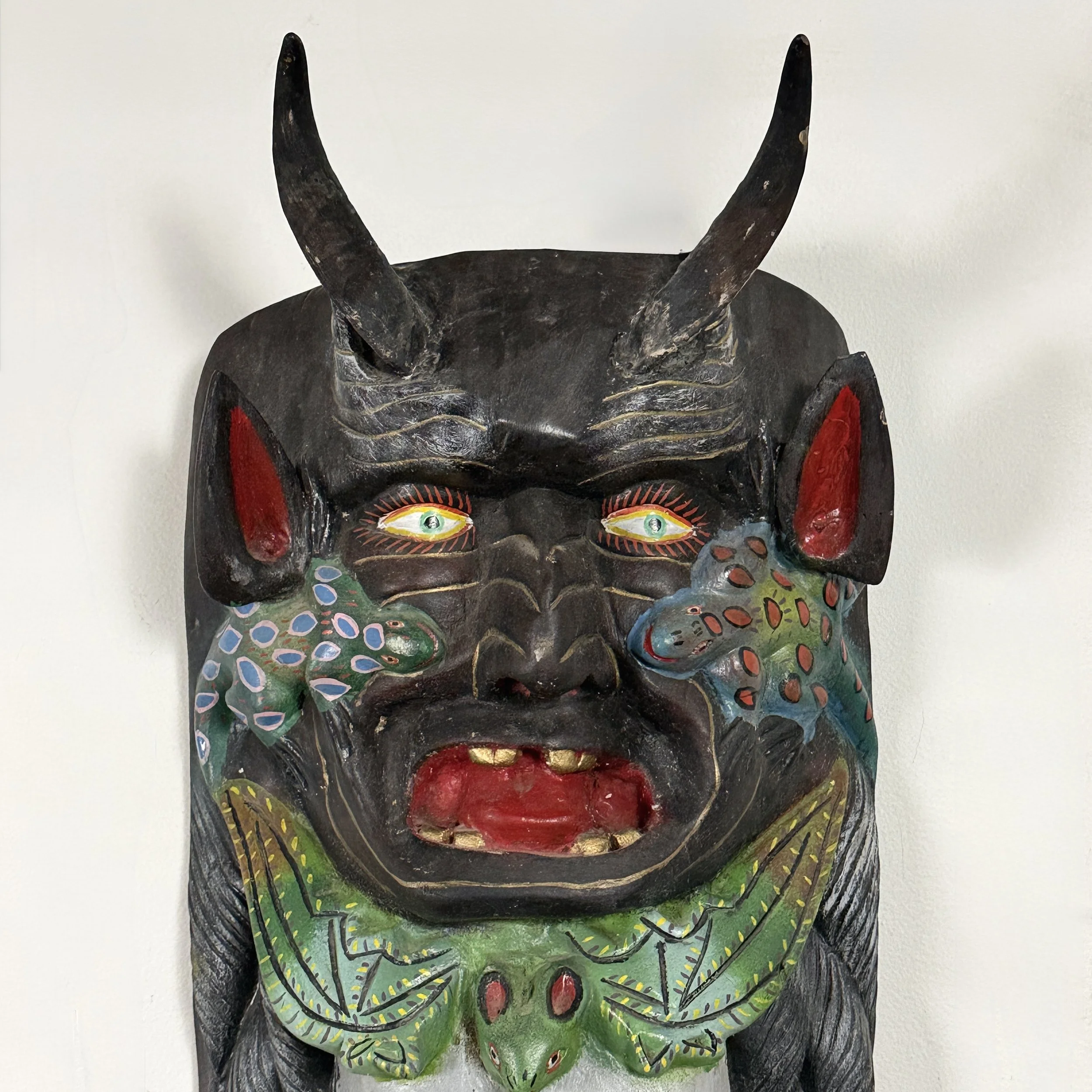Detailed view of the Devil at the top of the mask.