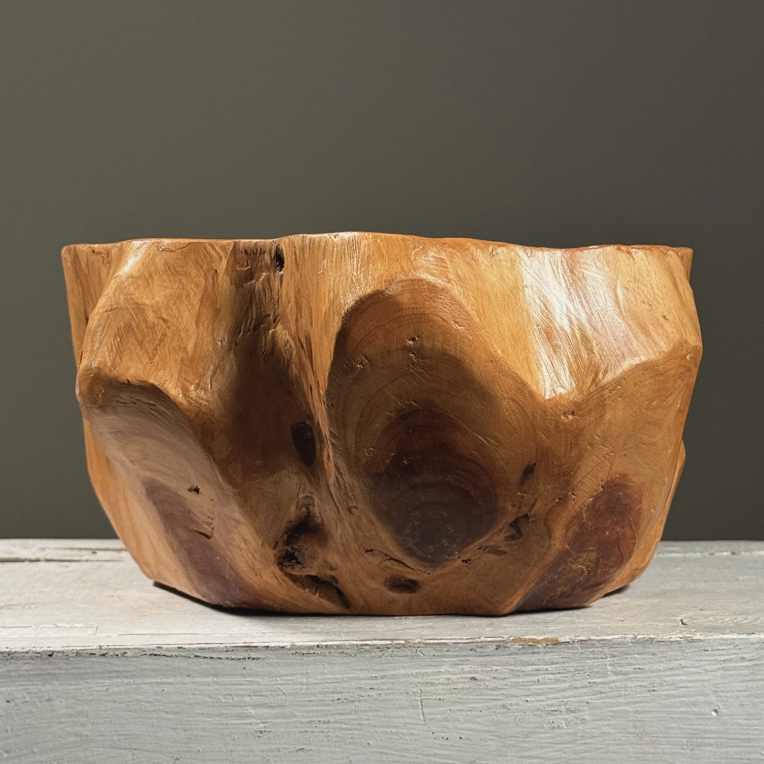 Full frontal view of a vintage hand-carved modernist root bowl with live edge exterior
