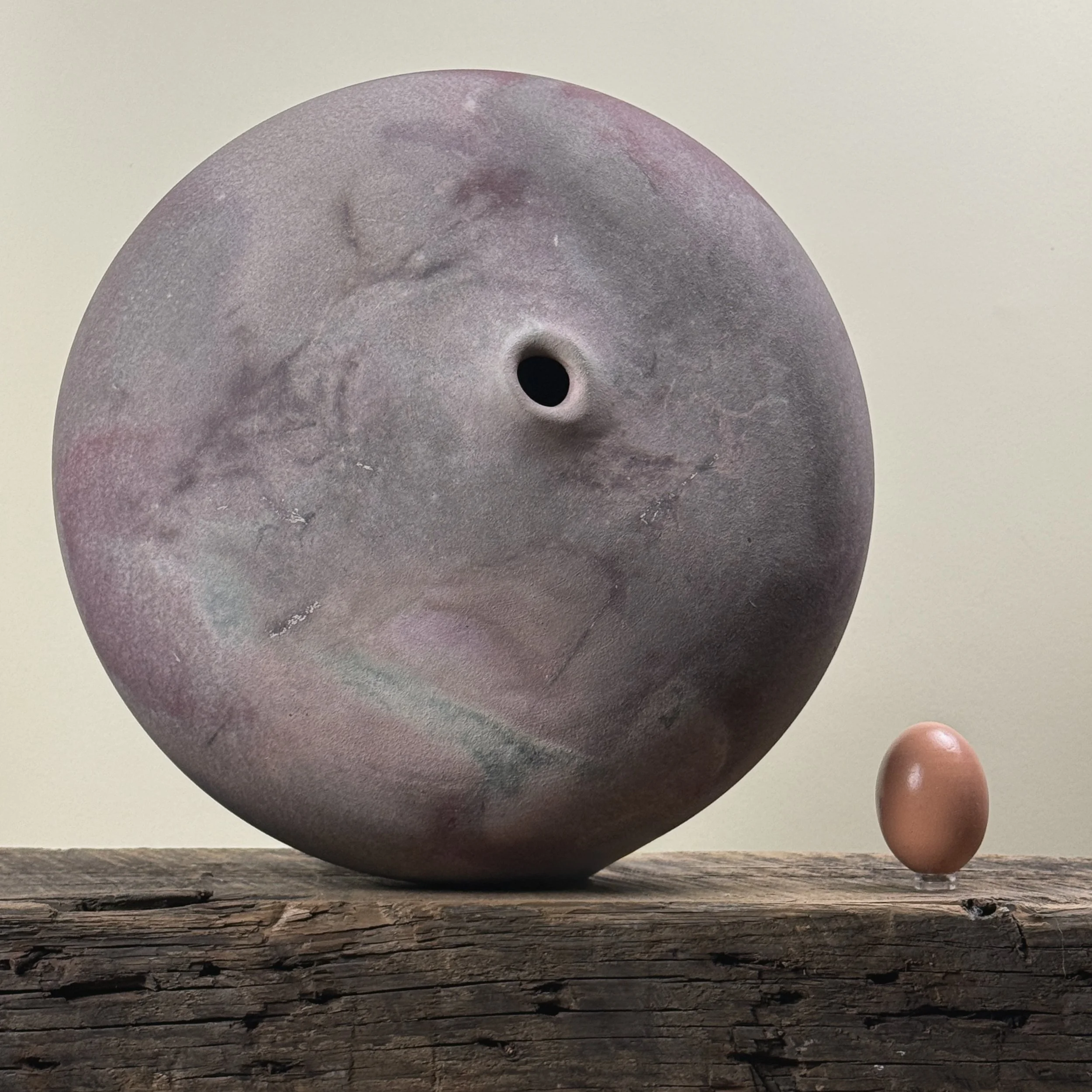 Jeffrey Zigulis large anagama fired seed pot vessel. Muted mauve and magenta hues. With egg for size reference.