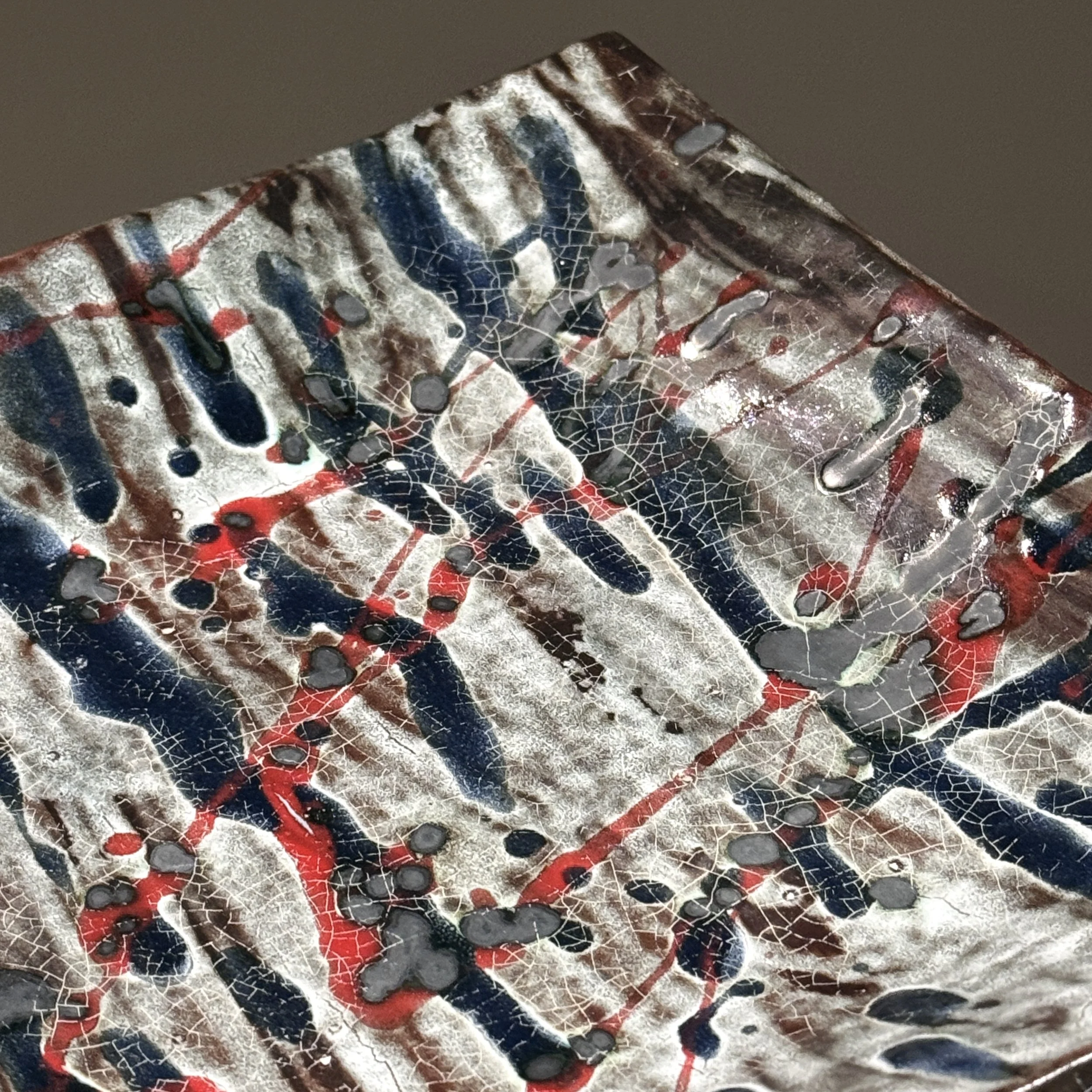 Detail of splatter glaze. Abstract Expressionist gesture. Blue and red pigment application.