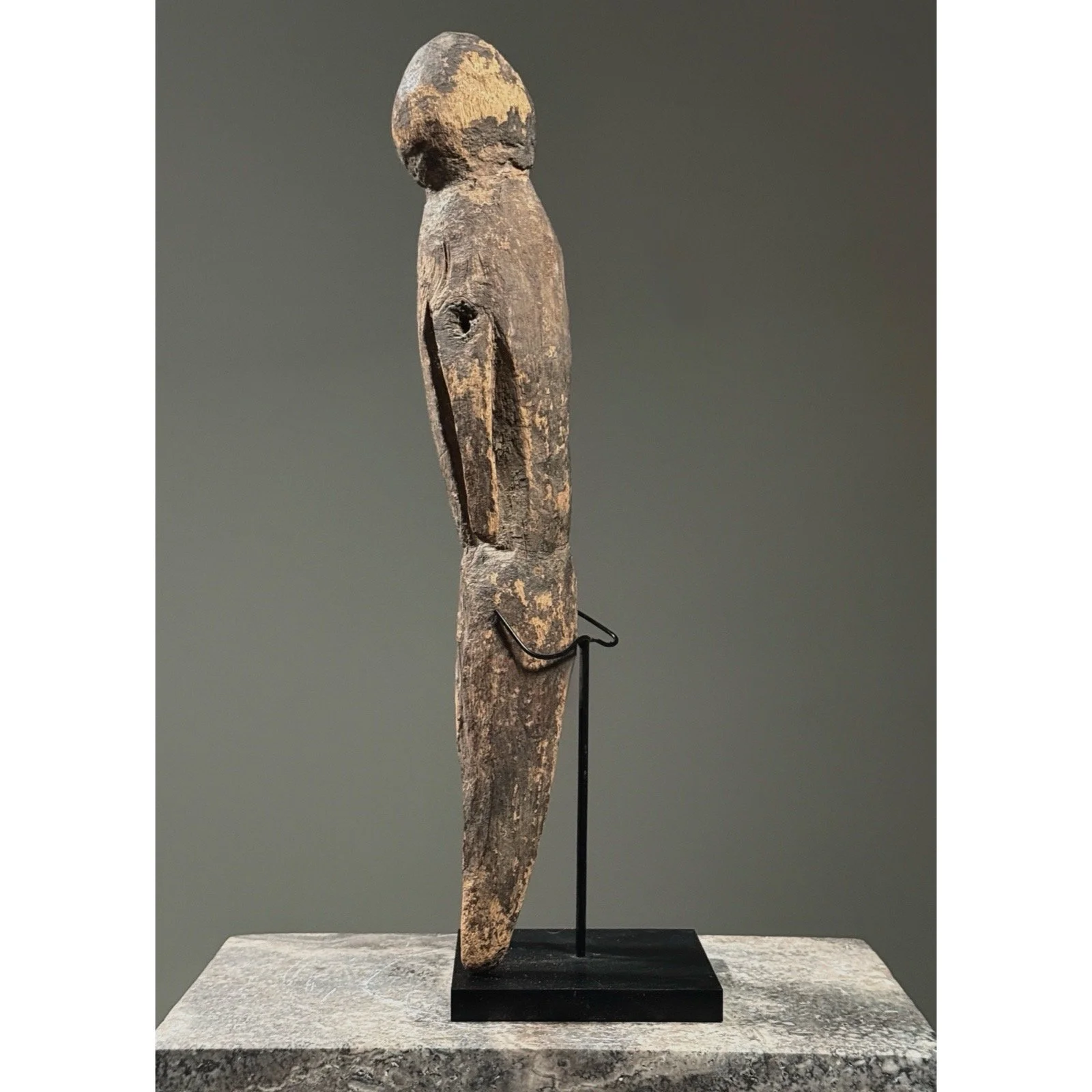 Side profile of a vintage Moba shrine figure demonstrating its cylindrical torso and simplified limbs