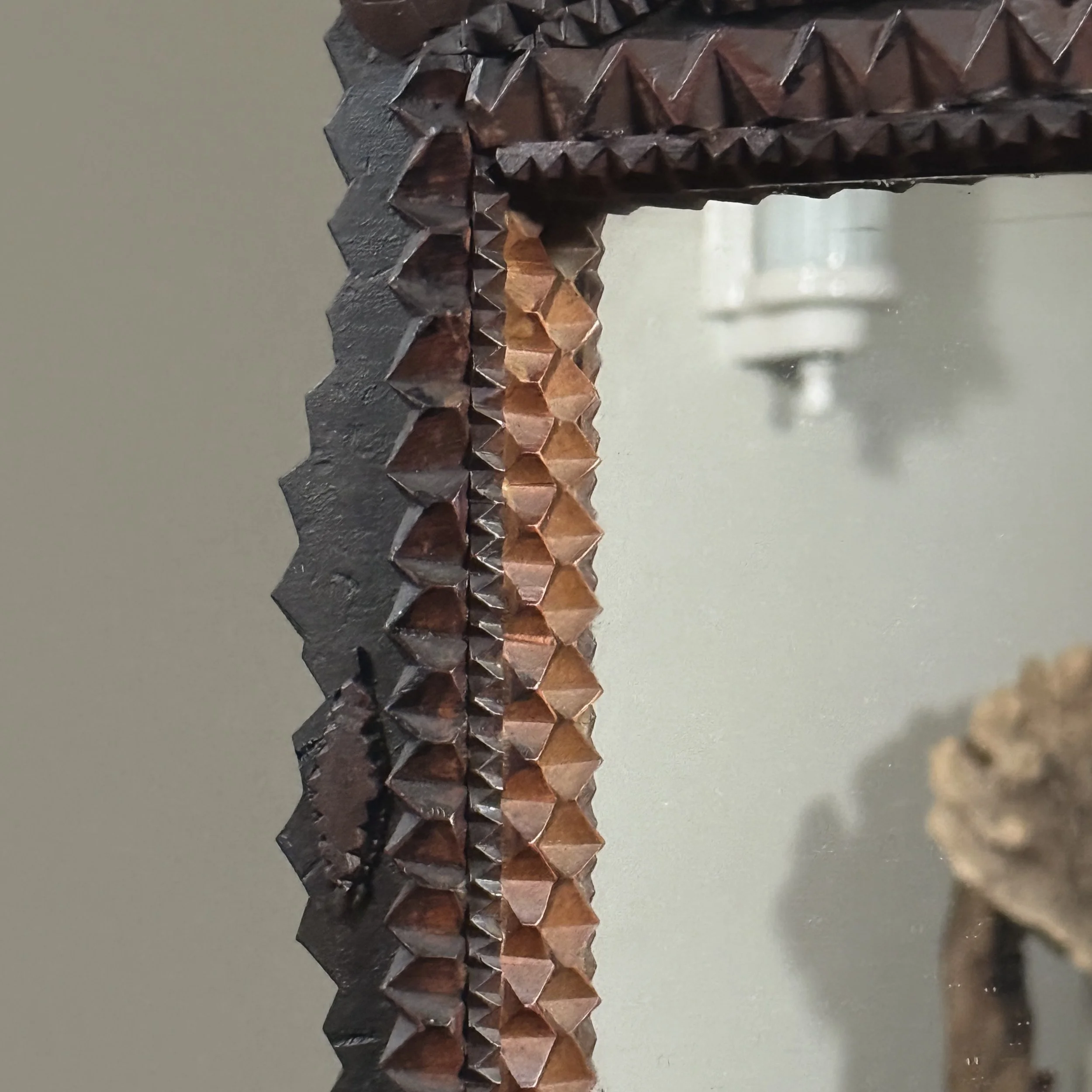 Close-up of the detailed chip-carving around the mirror frame.