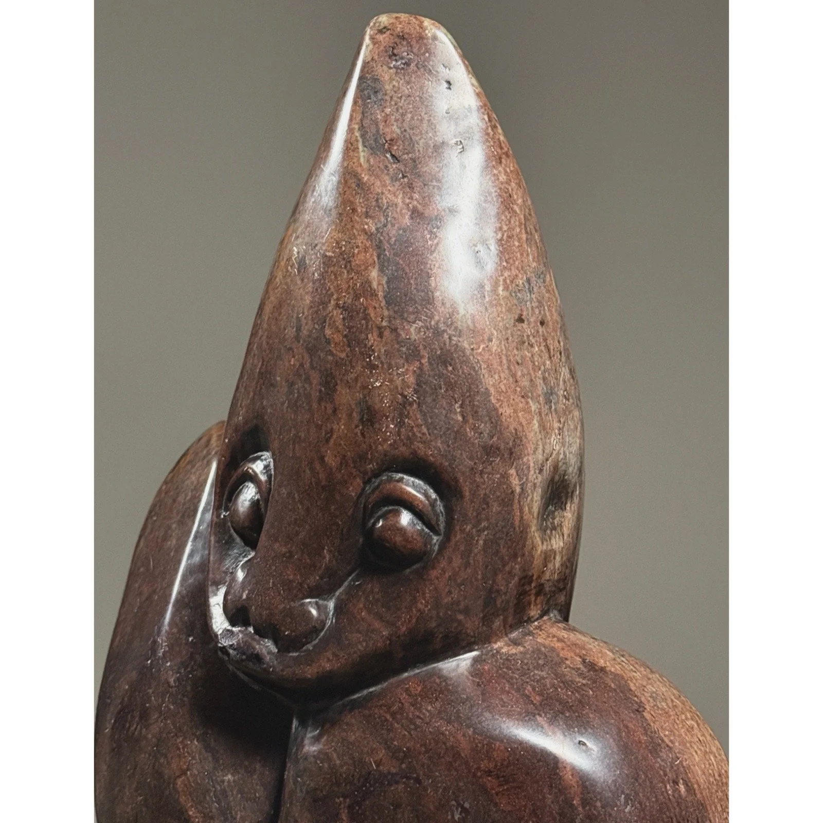 Three-quarter view of hand-carved abstract Zimbabwean sculpture showing smooth and textured stone surfaces.