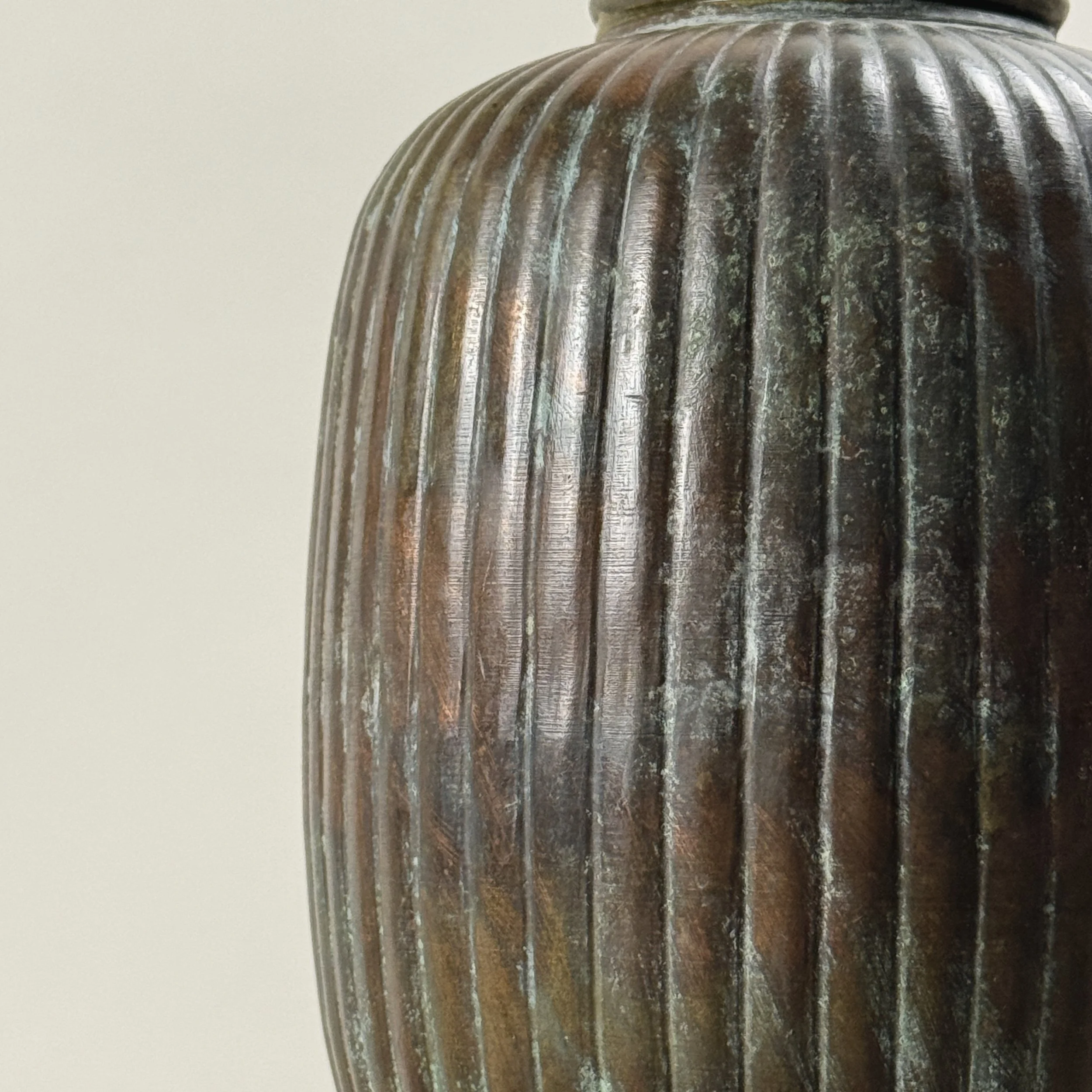 Detail view of verdegris patination on greyish-brown brass vase, Art Deco style, antique