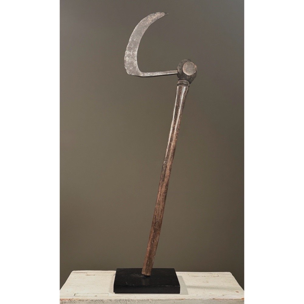 Full frontal view of an antique Bobo ceremonial axe from Burkina Faso with carved face at crux