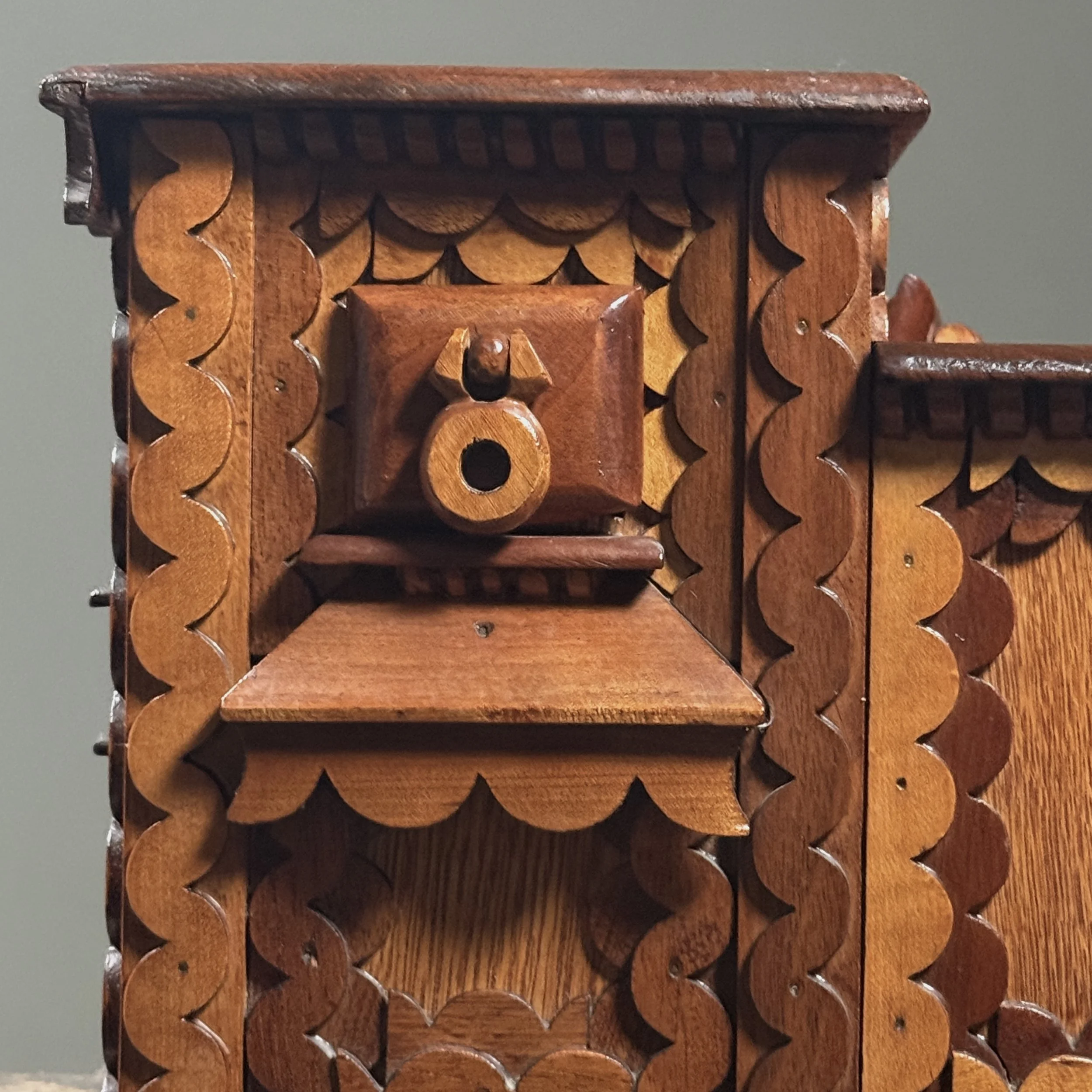 Close-up detail of layered "squiggly" scrollwork ornamentation on a vintage folk art box