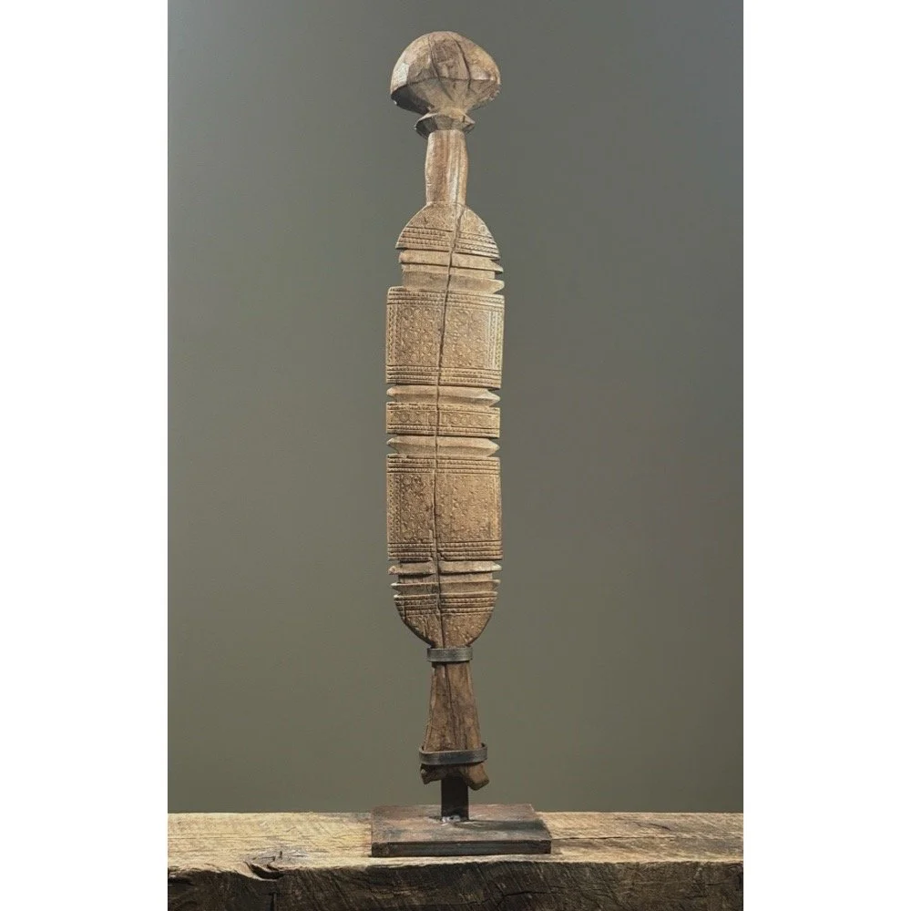 Full view of an antique Tuareg carved tent pole mounted on an iron stand.