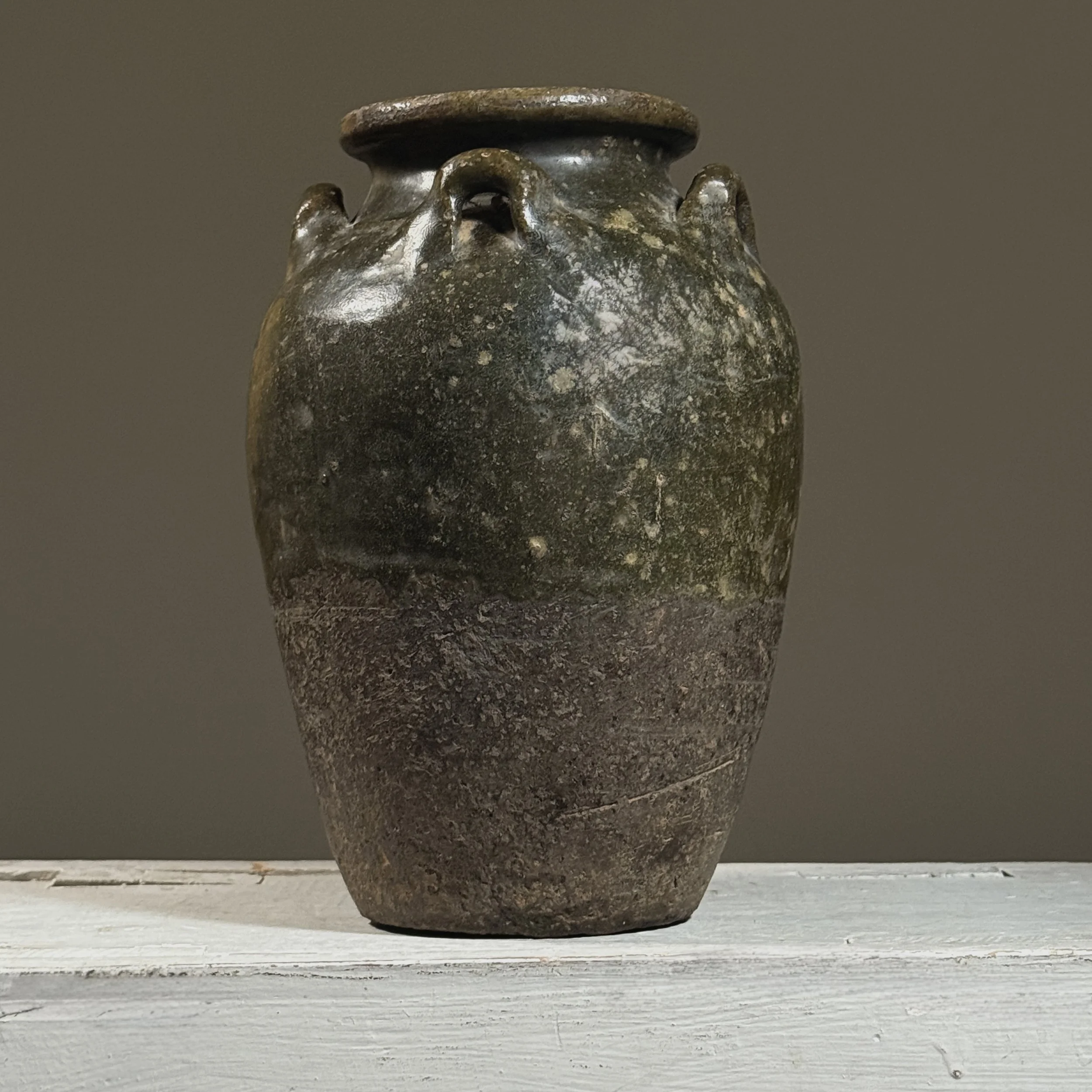 Front view of a Thai Sawankhalok glazed jar with four loop handles.