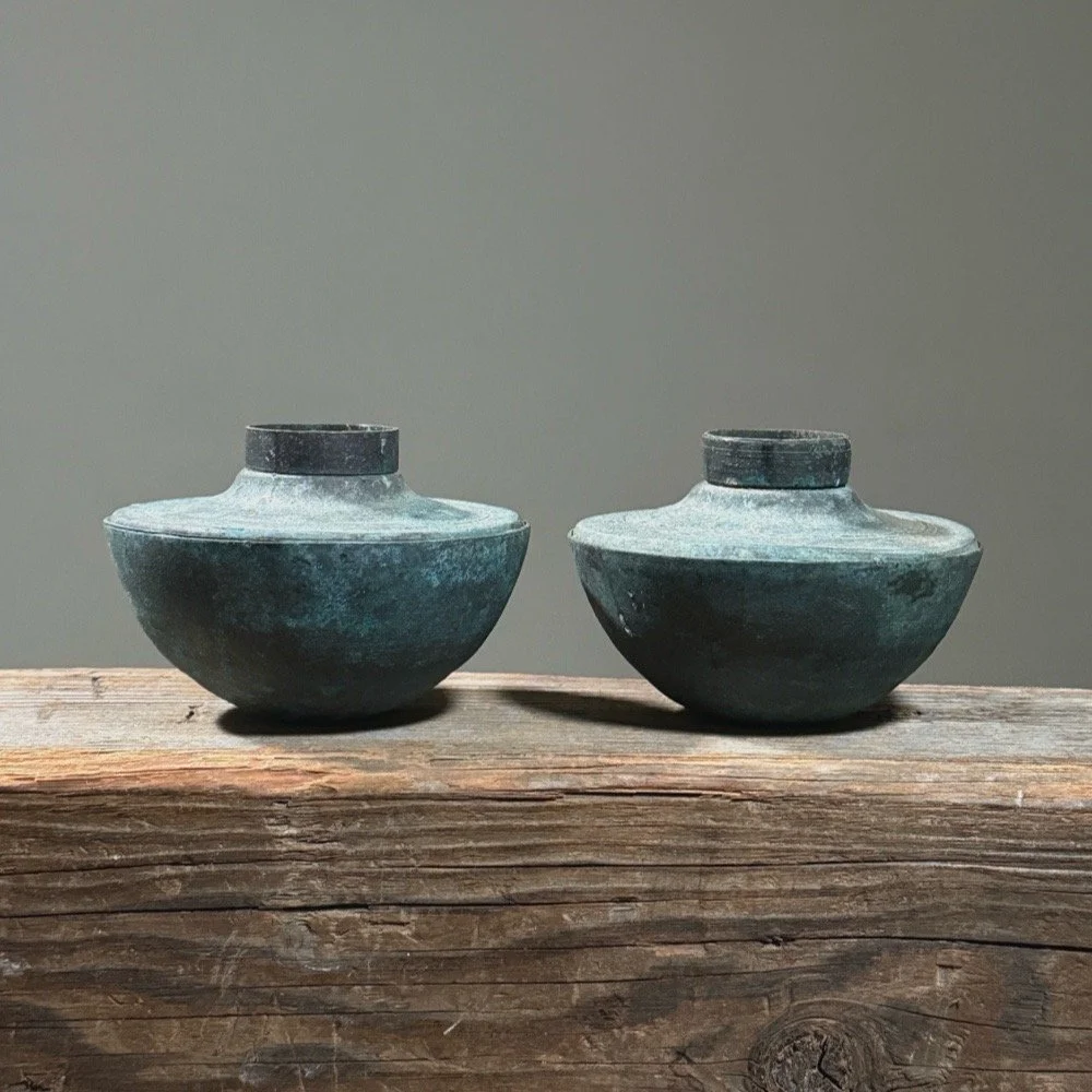 Front view of vintage Brutalist metal candle holder pair, verdigris patina, each 4.38 inches diameter by 3.25 inches height.