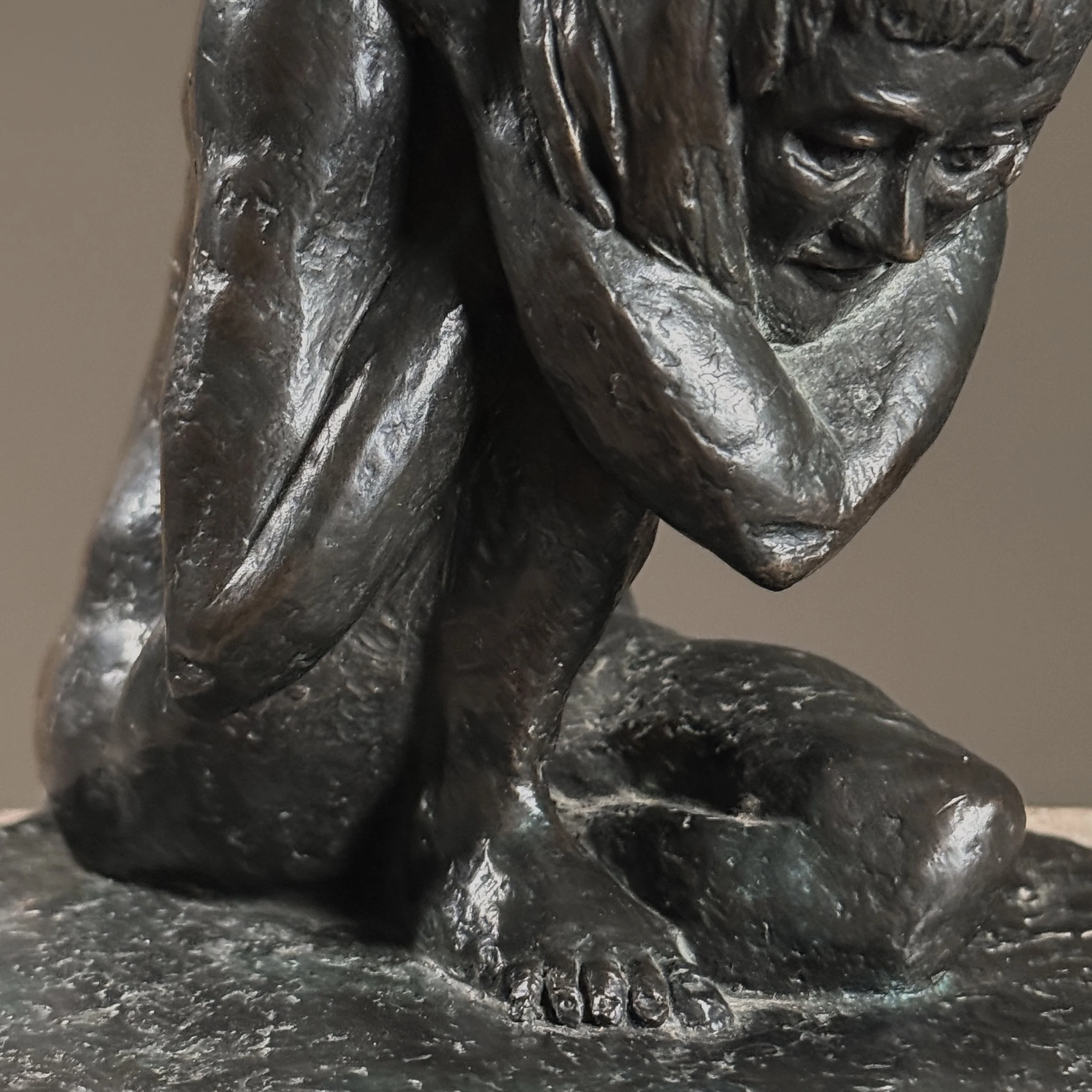 Close-up detail of the crouching nude's form and naturalistic anatomical modeling