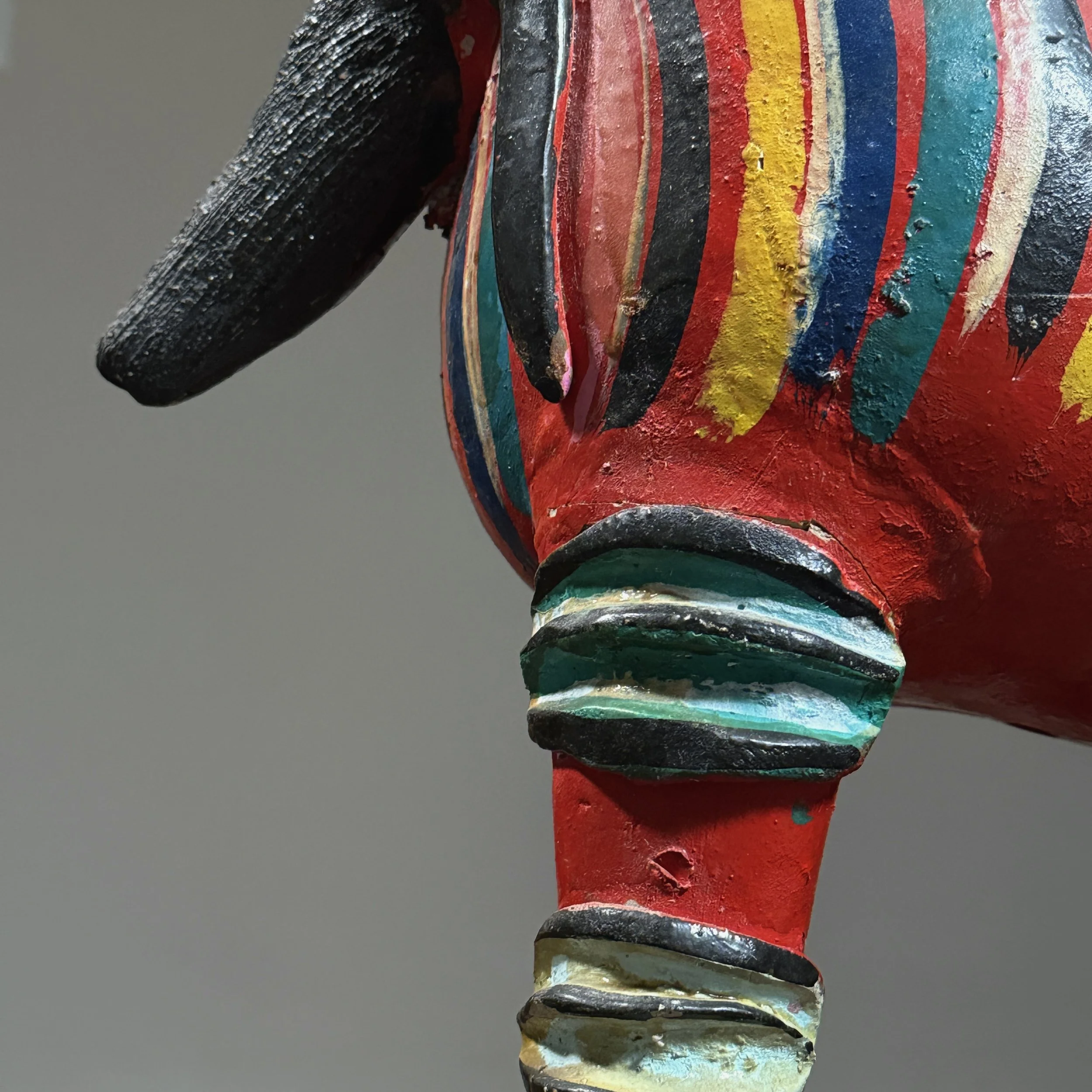 Detail of repairs visible on the legs of a vintage Candelario Medrano folk art monster sculpture