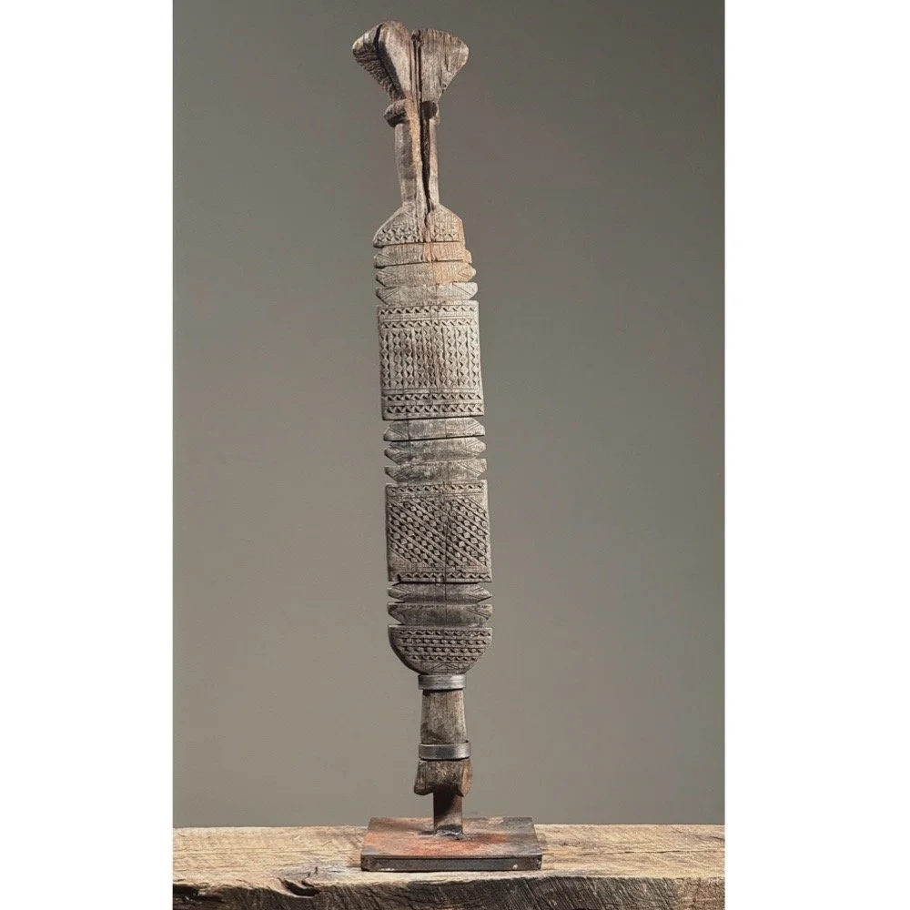 Full view of an antique Tuareg hand-carved wooden tent pole on custom iron stand.