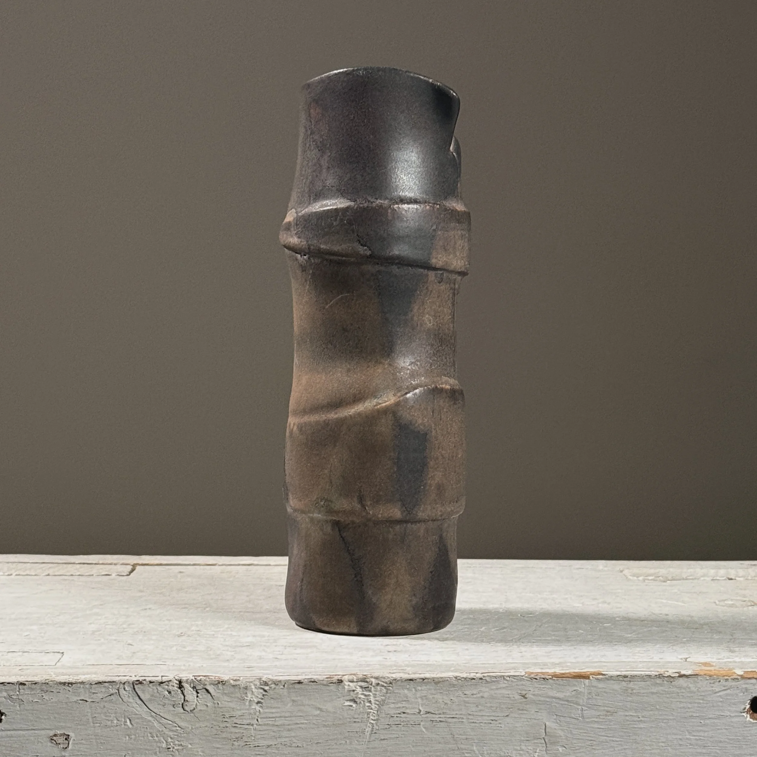 Front view of a vintage postmodernist wood-fired black ceramic vase.