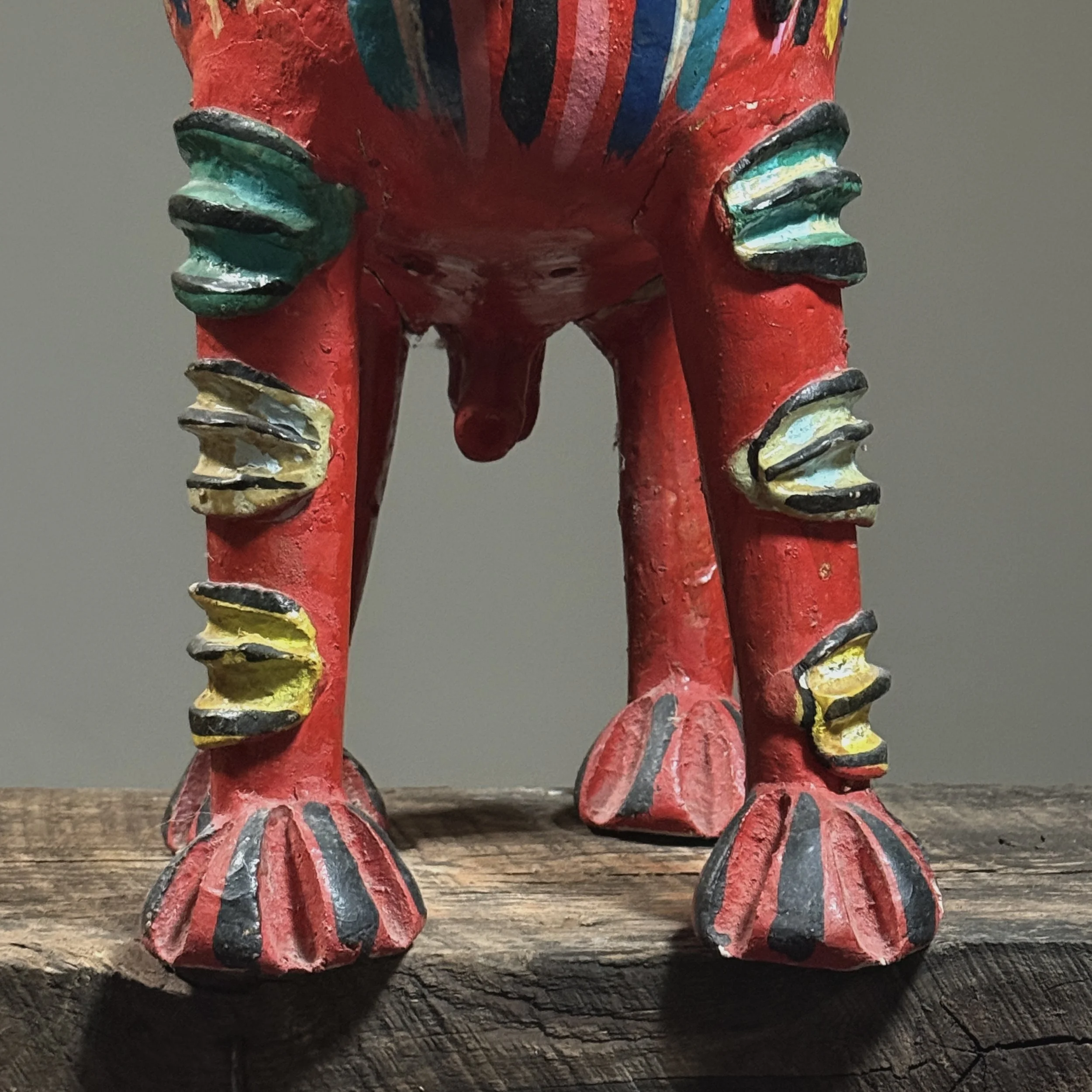 Detail of repairs visible on the legs of a vintage Candelario Medrano folk art monster sculpture