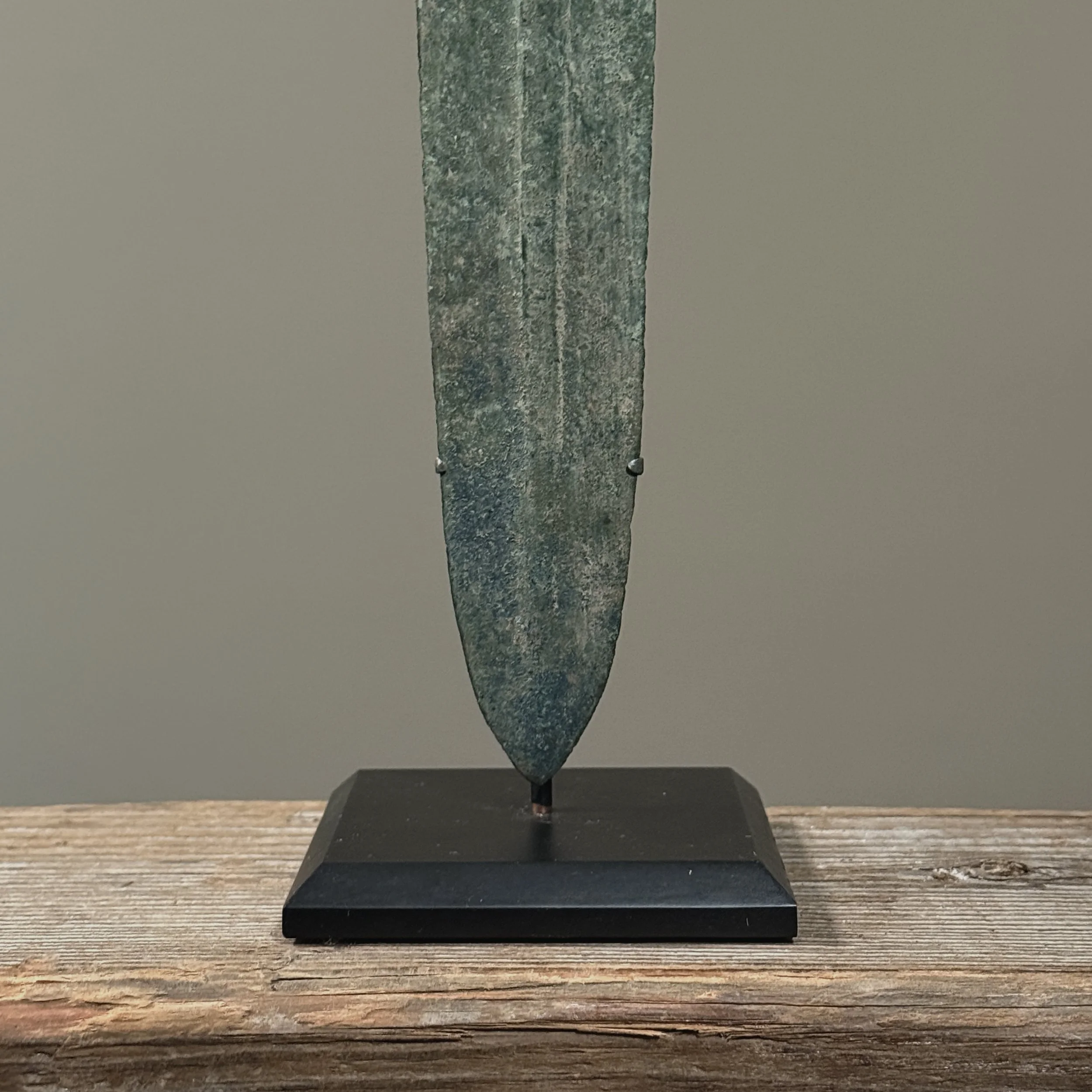 The sharp, tapered point and raised spine of the Luristan bronze blade.