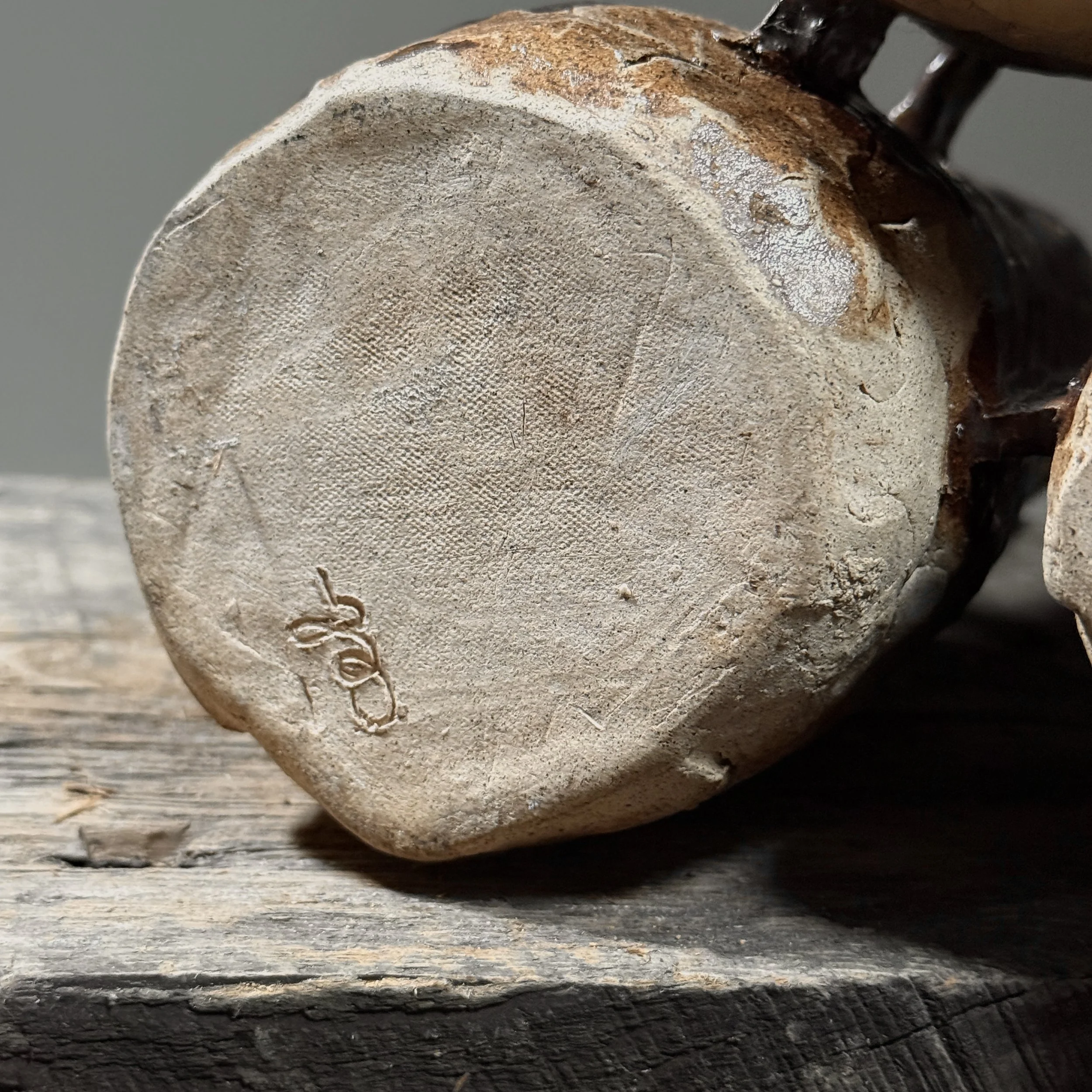 Detail of the artist's signature inscribed on the base of a vintage ceramic sculpture