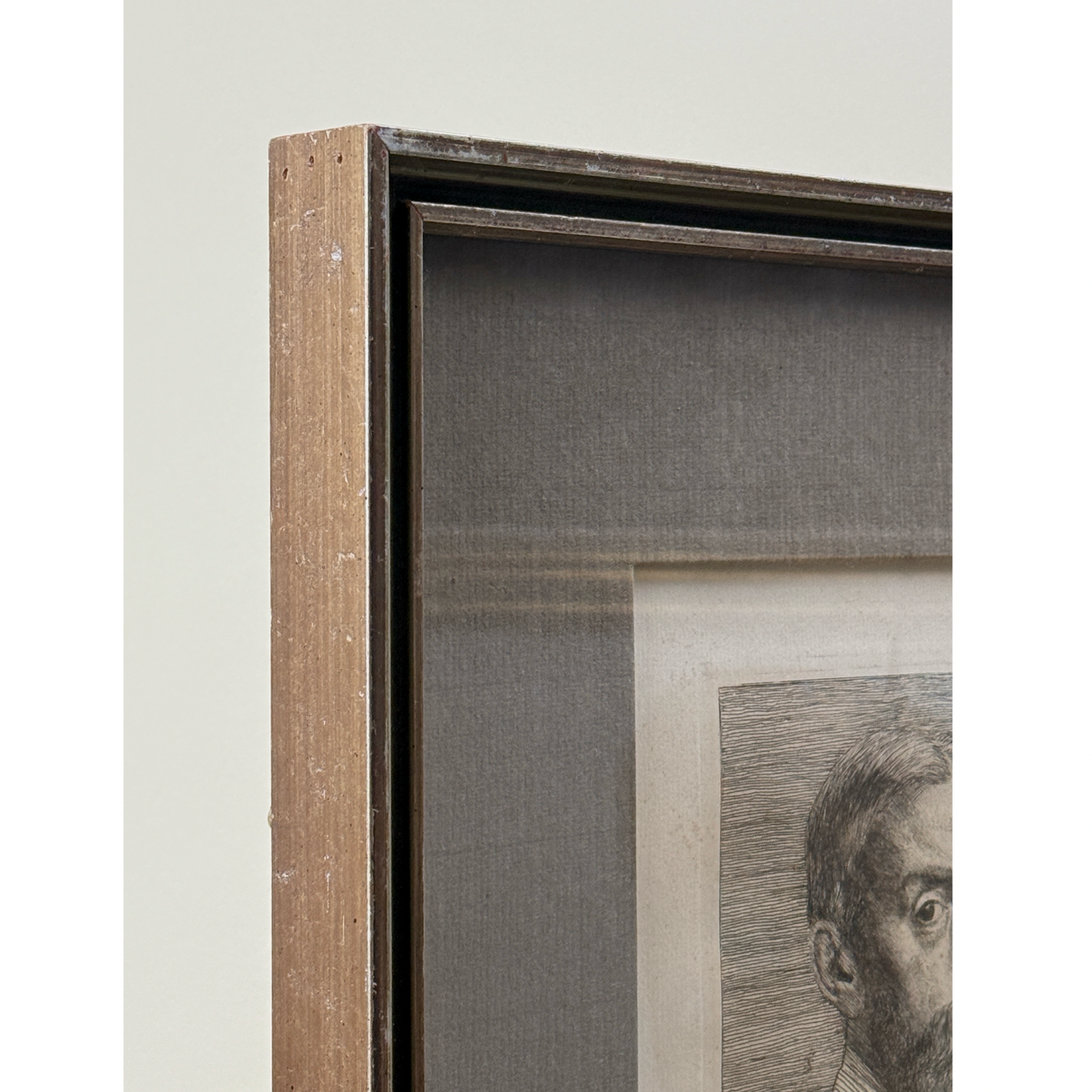 Frame detail. Patinated metal frame. Grey fabric mat.