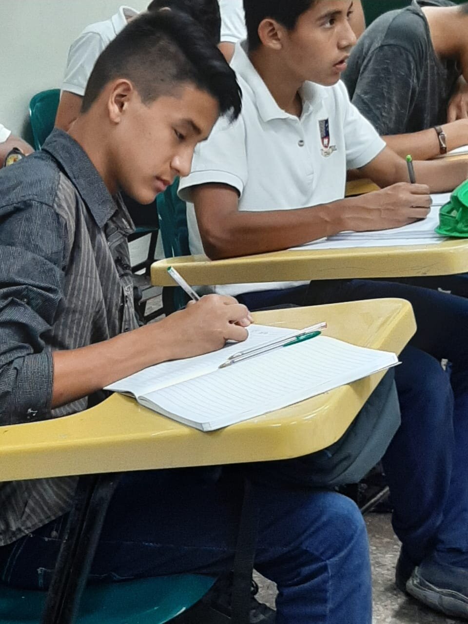 El Salvadorian student sitting at their desks working on an assignment