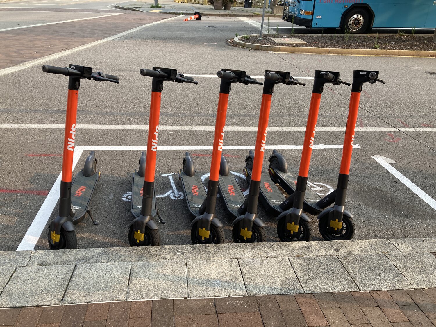 Spin scooters properly parked at a scooter corral