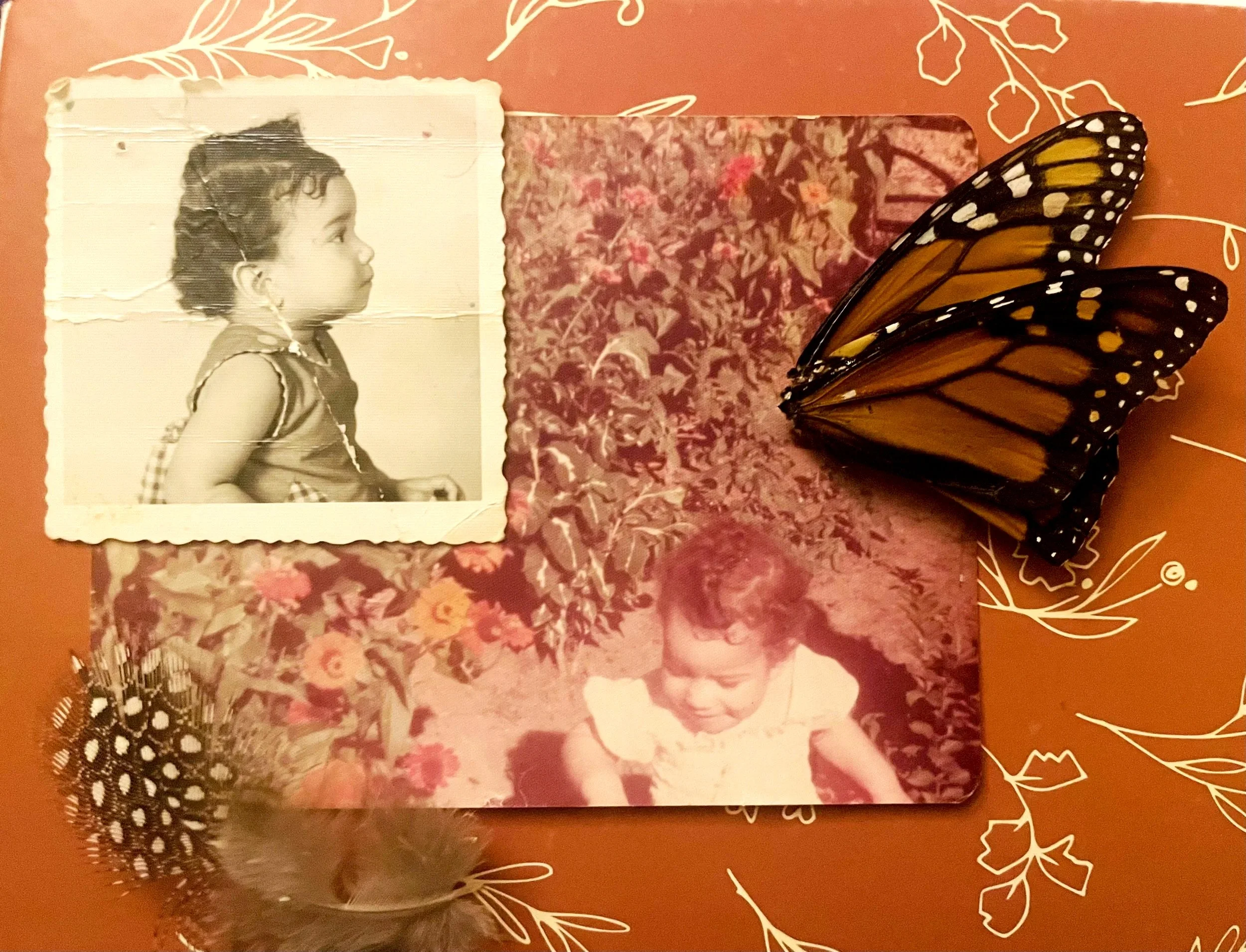 A scrapbook page with two childhood photos of artist, decorated with monarch butterfly wings and feathers. The background is orange with white floral illustrations.