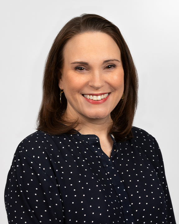 A woman smiling and holding two speech bubble signs, one with a white ribbon symbol and the other with a stylized digestive system, representing health awareness and digestive health.