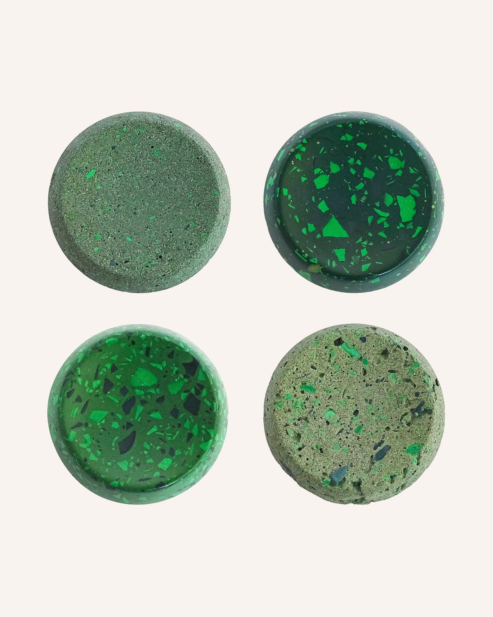 Set of green terrazzo and raw stone basketball display stands, Edo Ball bases in polished and pitted finishes for collectible art basketballs.