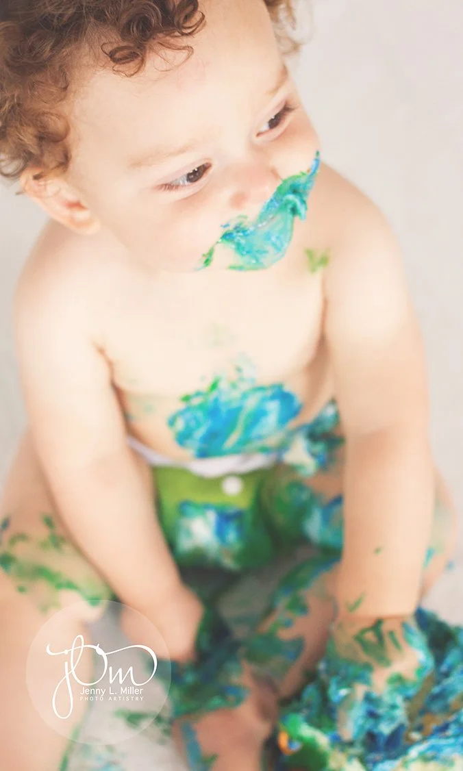 Happy baby covered in cake he's eating