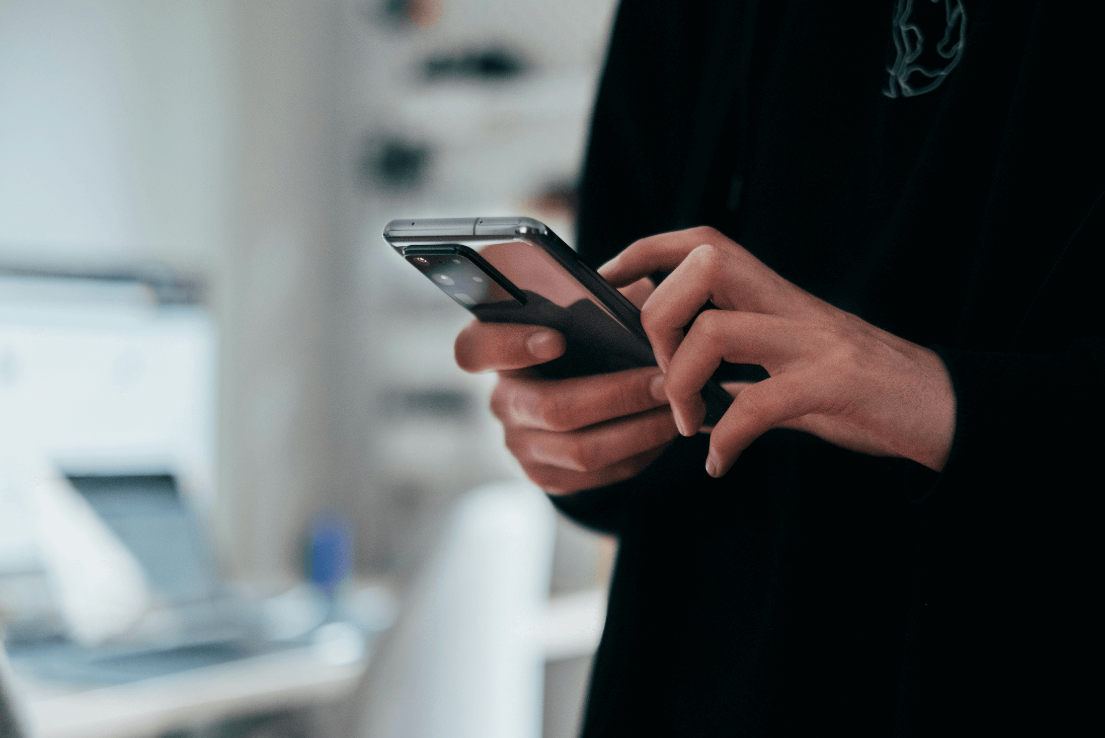 Hand holding a smartphone while scrolling, illustrating access to mental health support and connecting with a complex PTSD therapist near me in Farmington Hills, MI.