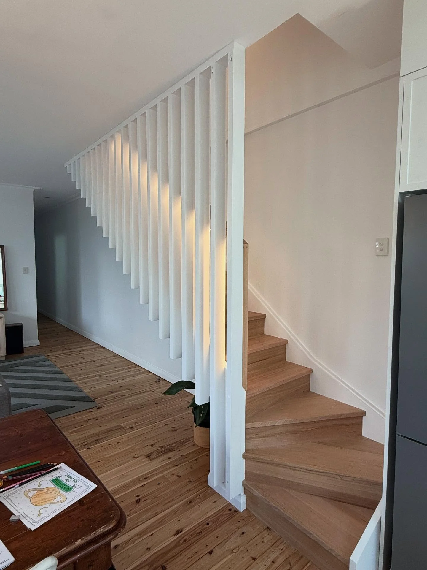A timber staircase and painted screening at our Croydon project. Stained Vic ash treads and riser with a LED strip routered into the handrail