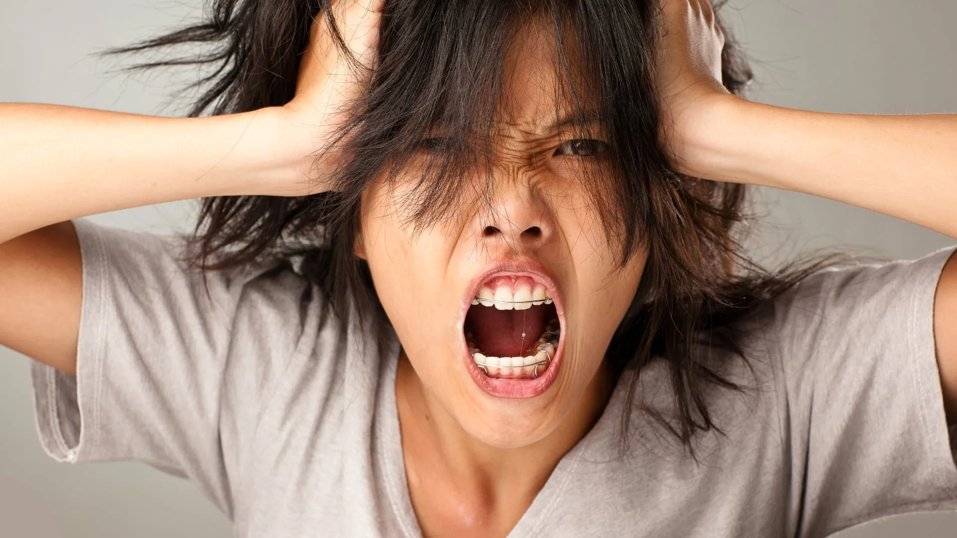 Woman angry holding her hair and shouting.