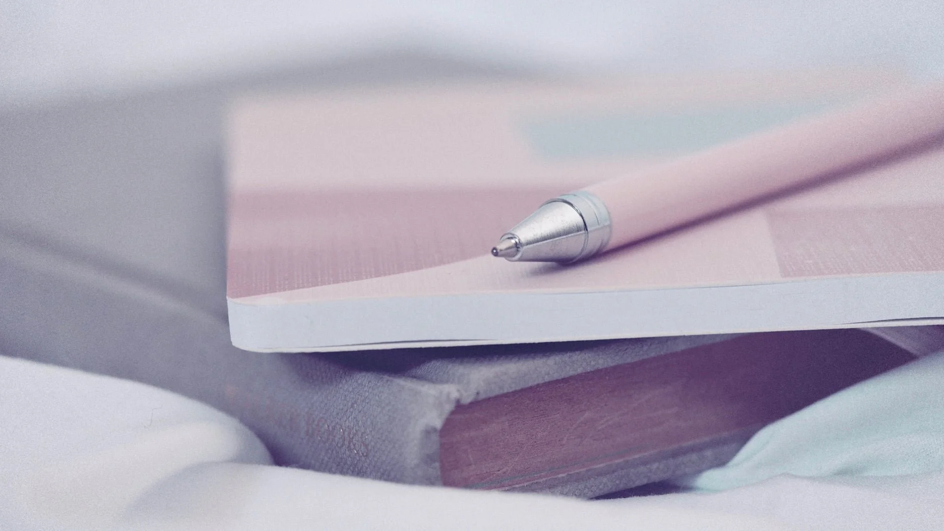 Notebook with pink pen on top.
