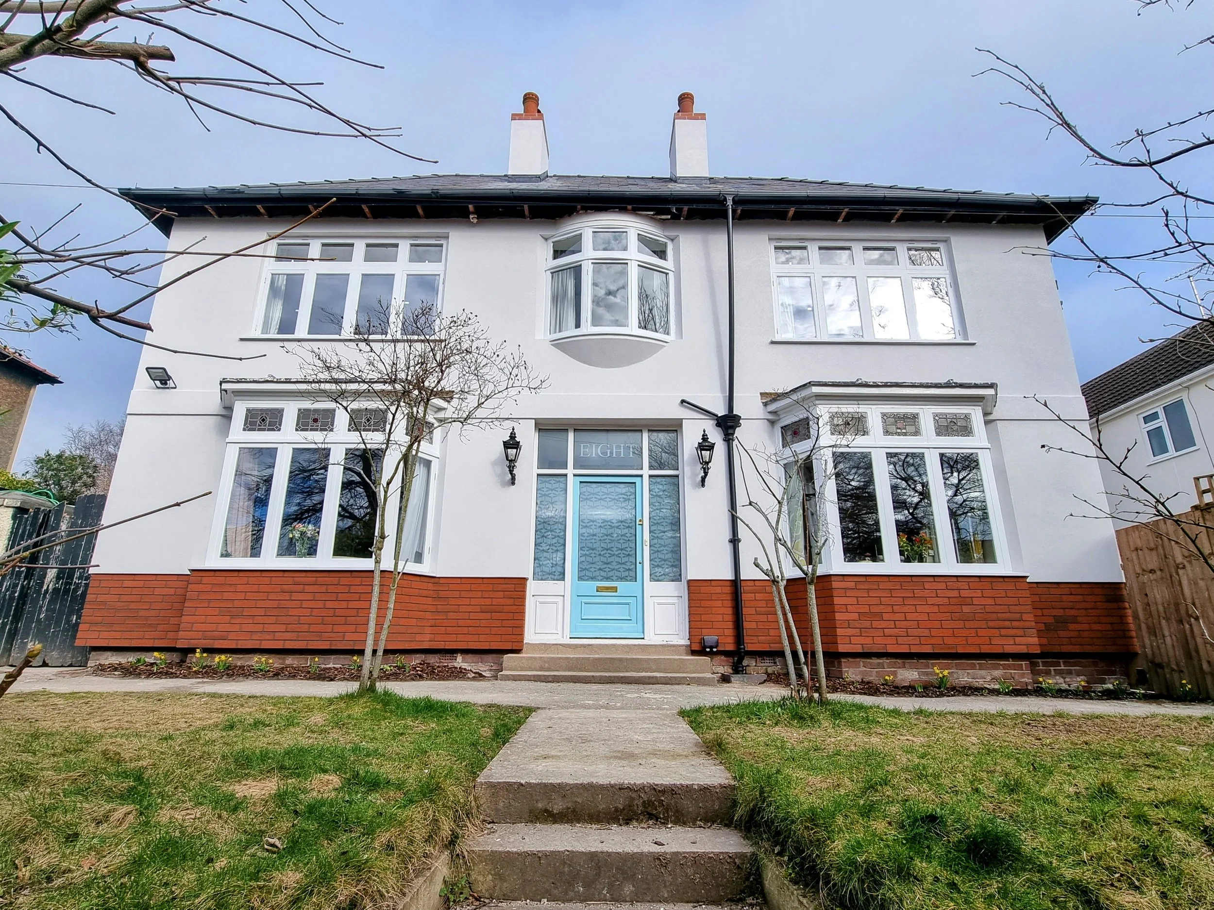 White two-story house with red brick base, EWI, external wall insulation, brick slips, silicone render, K Rend