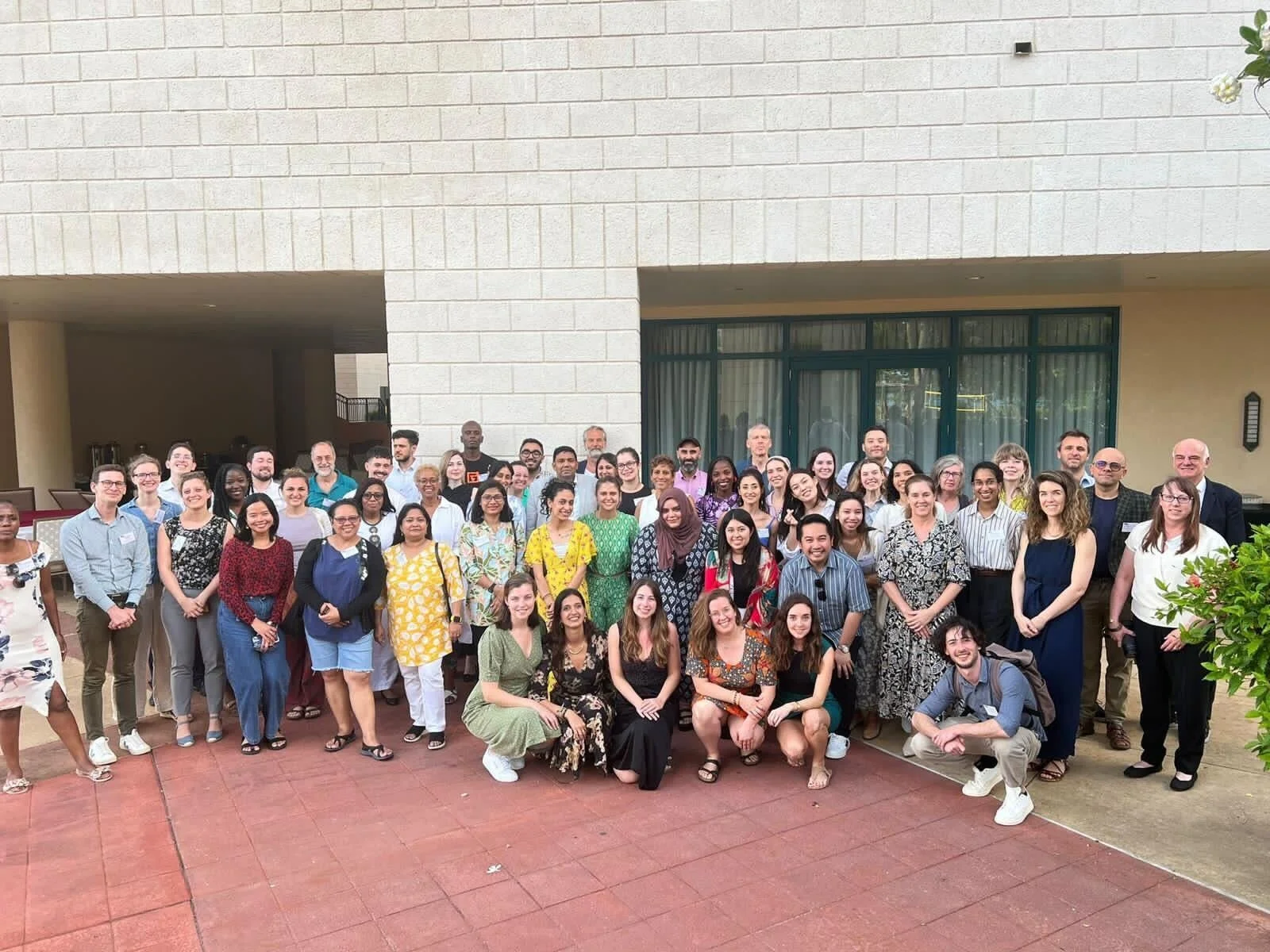 A landscape photograph of over 40 people posing for a group photo. Everyone is standing except for 6 people crouching at the front.
