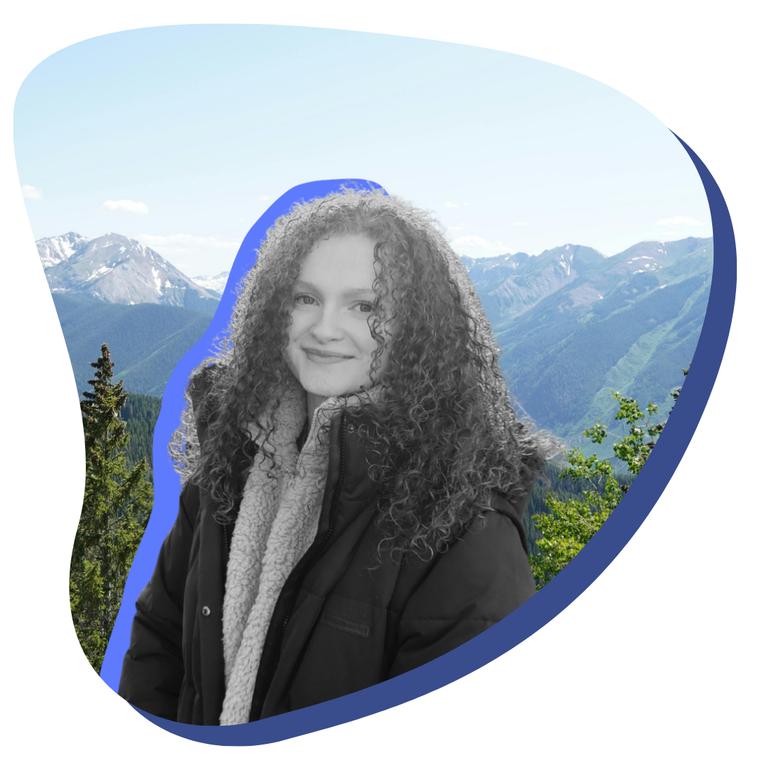 Black and white photo of a white woman with curly hair smiling at the camera. The photo is cutout and placed on a nature image with a blue outline.