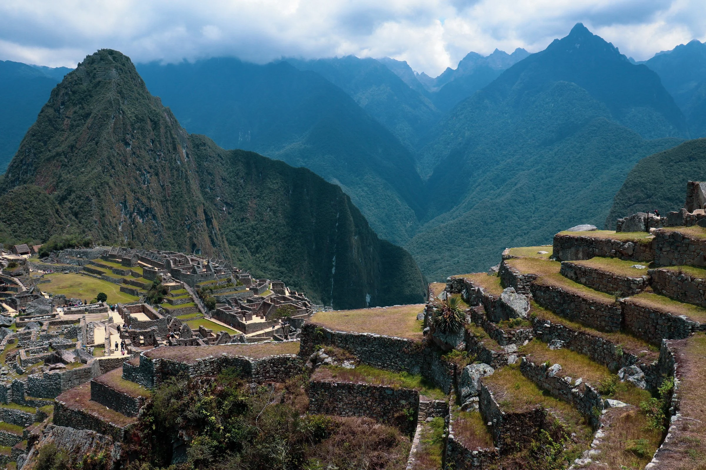 Ancient Incan ruins at Machu Picchu with terraced stone structures and mountain landscape in the background.