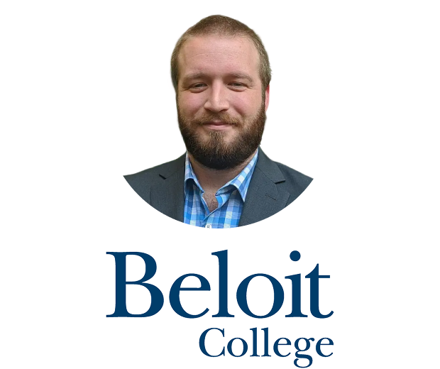 A white man with light brown short hair, beard, and mustache wearing a suit and white and blue checkered shirt close-mouthed smiles at the camera in front of a yellow background with the Beloit College logo below him.