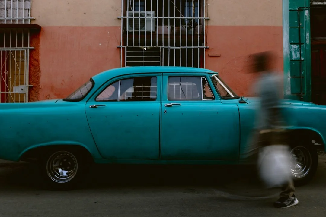 A quiet street in the heart of Havana sets the scene for my first attempt at street photography back in 2019. My subject, a teal classic car rests, its paint worn to a textured patina. Bars on the windows and peeling plaster tell a story of resilienc