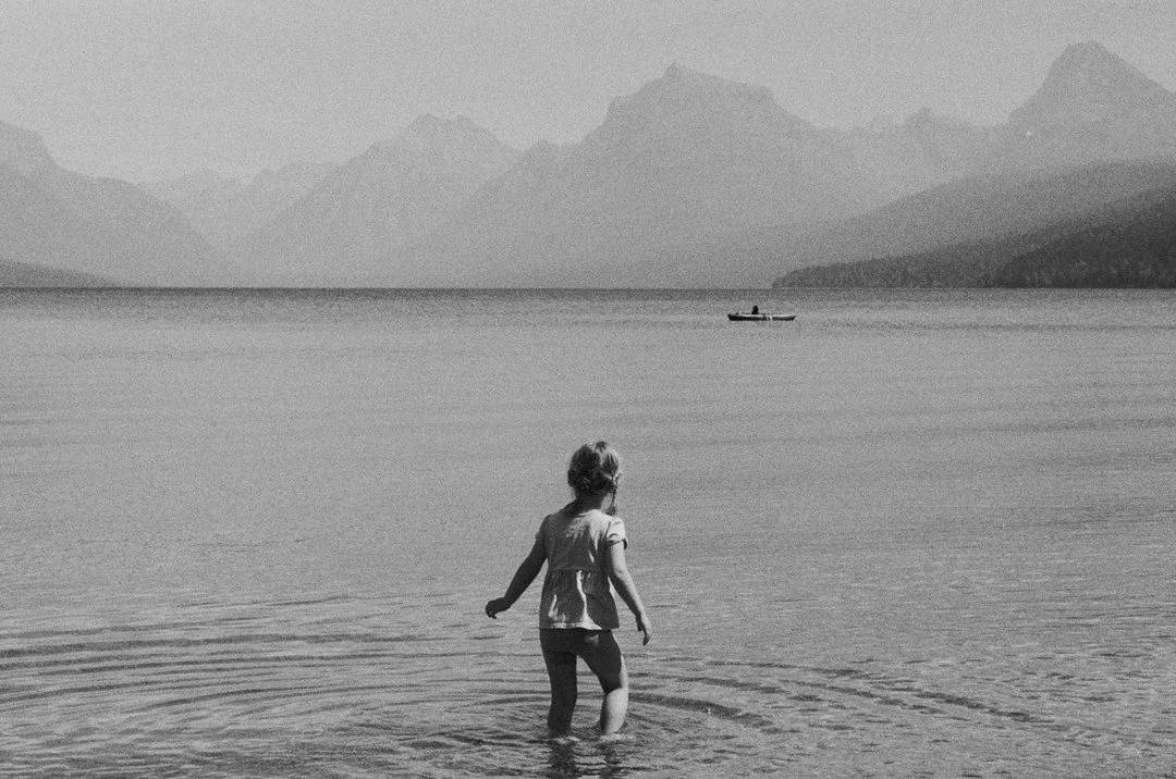 It was a late summer afternoon at Lake McDonald, and the sun hung low, casting a warm glow over everything. Katherine stood by the shore, taking it all in. The stillness of the lake mirrored the quiet of the moment&mdash;just us, the soft hum of natu