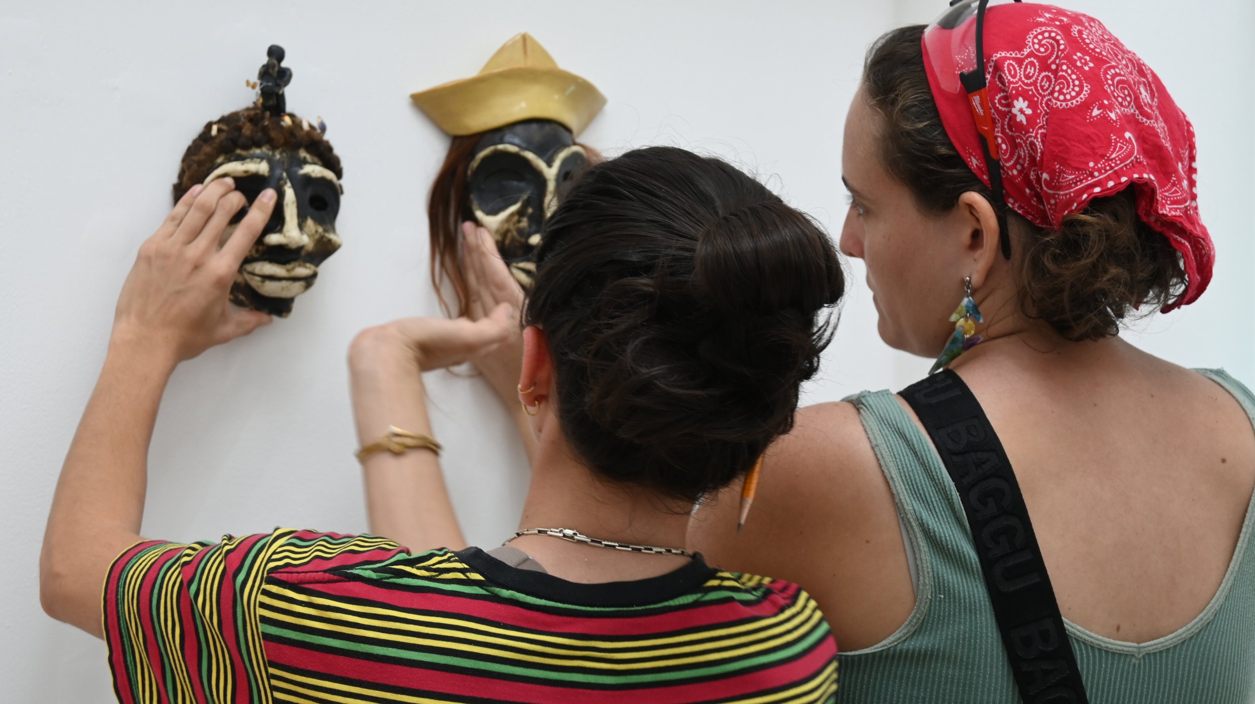 La artista Jenney López Figueroa instalando su obra junto a la artista Kristal Juan.