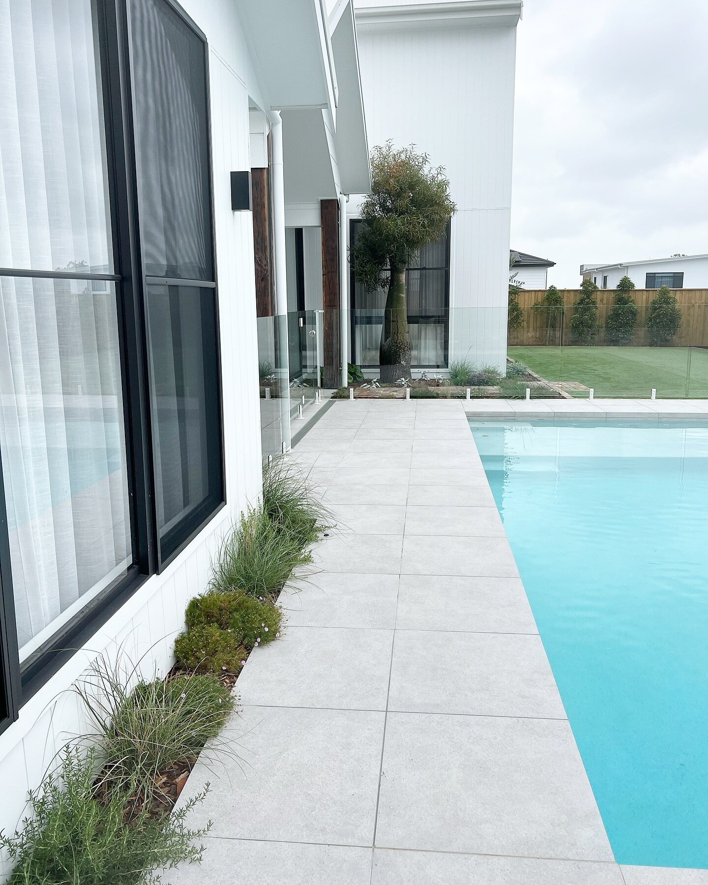 Uncomplicated modern design and clean lines. 

Porcelain tiles, pops of recycled brick, green green grass, white spigots and that big beautiful Boab tree the focal point from inside and outside the home. 

Pool + Landscaping: @outsideindulgence_lands
