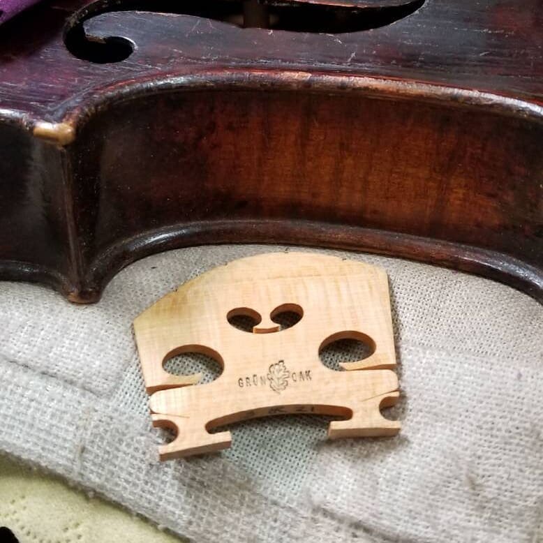 Brandi was working on replacing a bridge on a customers lovely old Juzek violin. I believe it was from 1919. This was our first walk in customer to our new shop! I need some party poppers over here. 

#artisan #luthier #luthiery #violin #grunoak #ins
