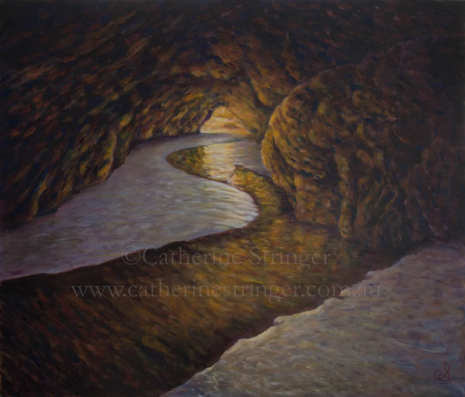 creek in intertidal cave flowingt through to the sea